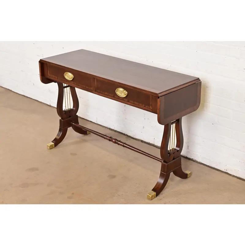 An exceptional English Regency or Georgian style drop leaf writing desk, console table, or sofa table

By Baker Furniture

USA, Circa 1980s

Mahogany, with satinwood banding, original brass hardware and accents, and brass-capped feet. 

Measures:
