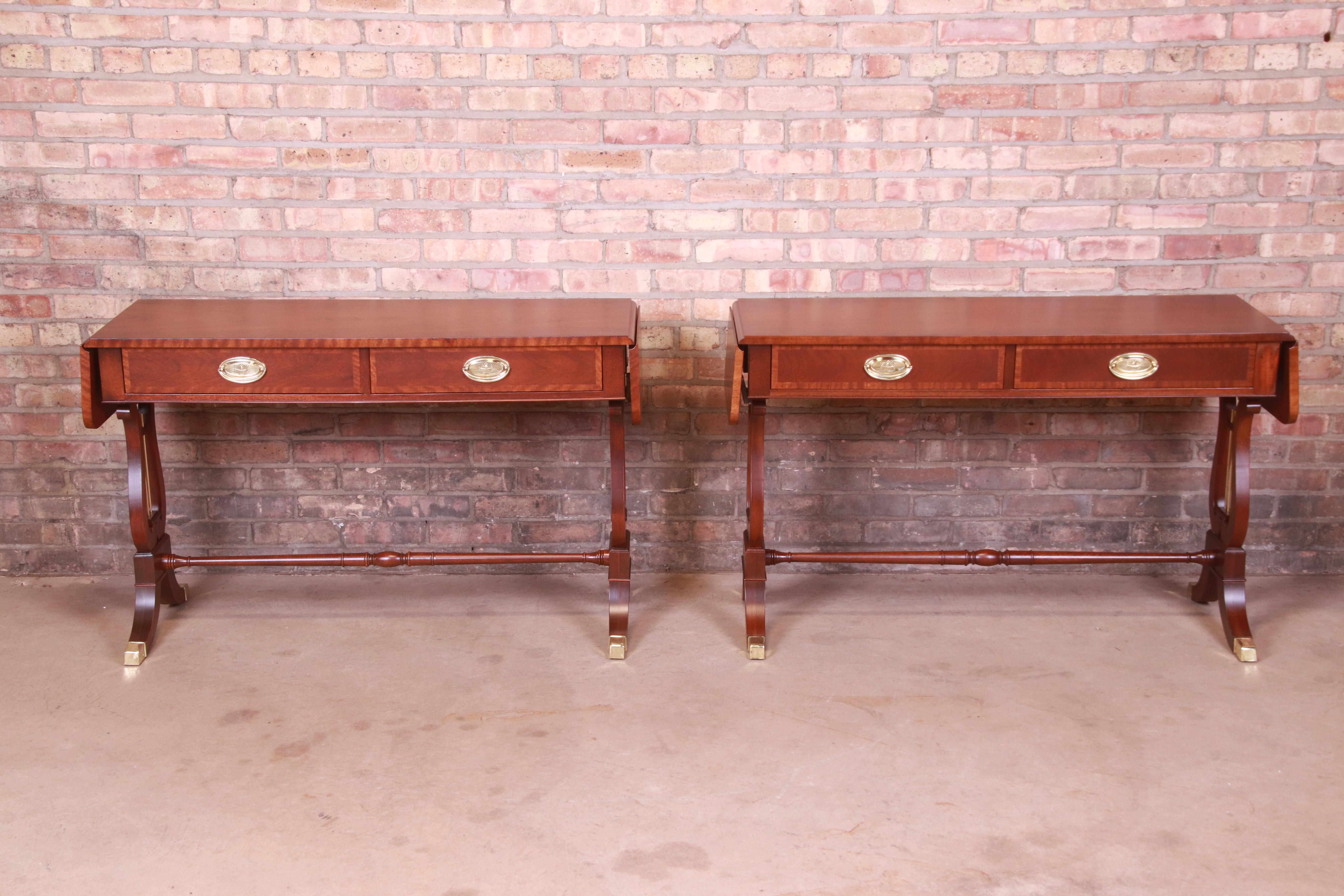 An exceptional pair of English Regency or Georgian style console tables or sofa tables

By Baker Furniture

USA, Circa 1980s

Banded mahogany, with brass accents, brass-capped feet, and original brass hardware.

Measures: 45.25