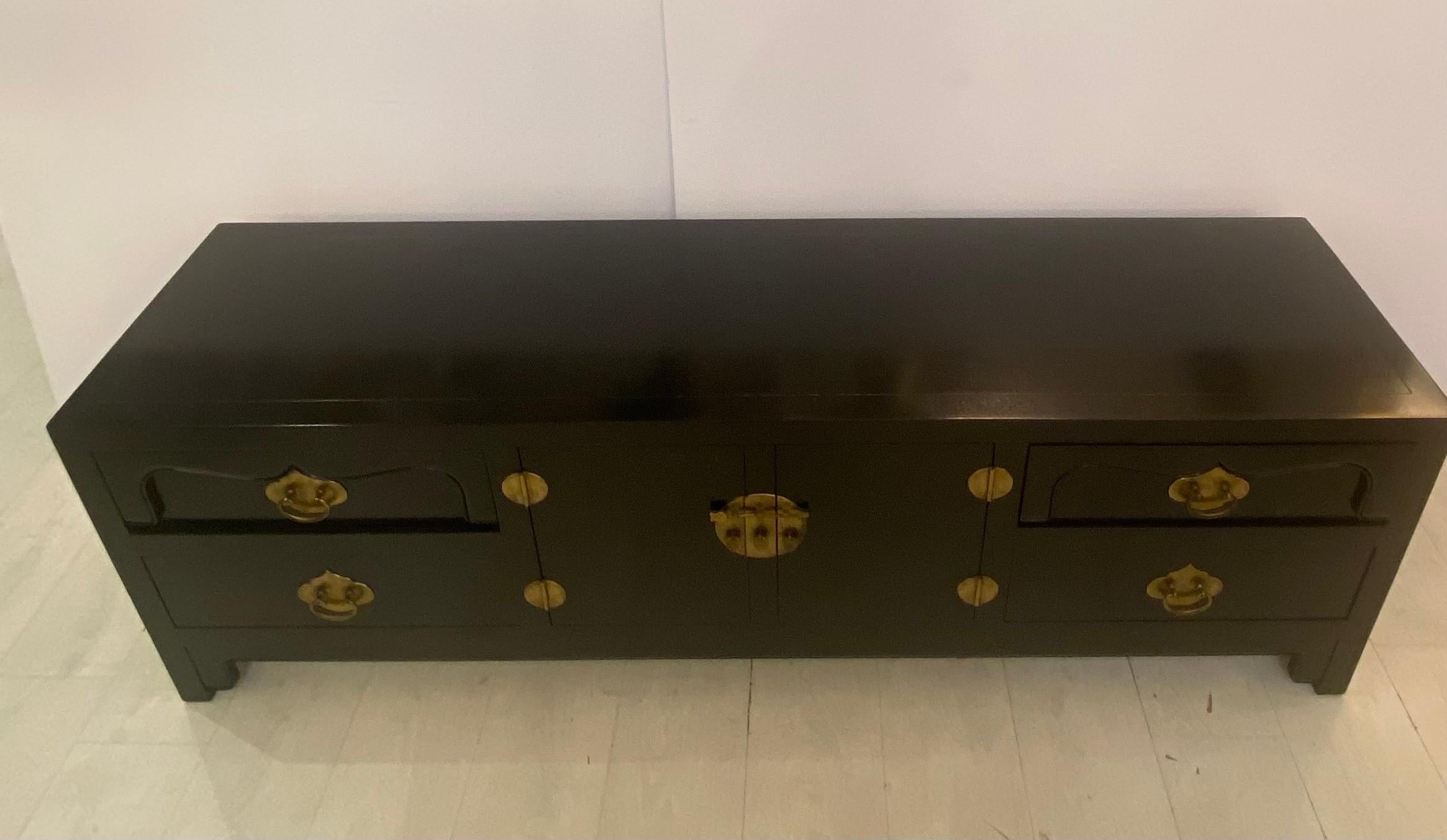 A rare low credenza with four drawers and two doors… In the far is style with high-quality brass fittings and trim… Constructed from fine mahogany secondary woods .. Do the lacquer black finish… Impeccable condition 67 1/2 inches long 22 1/4 inches