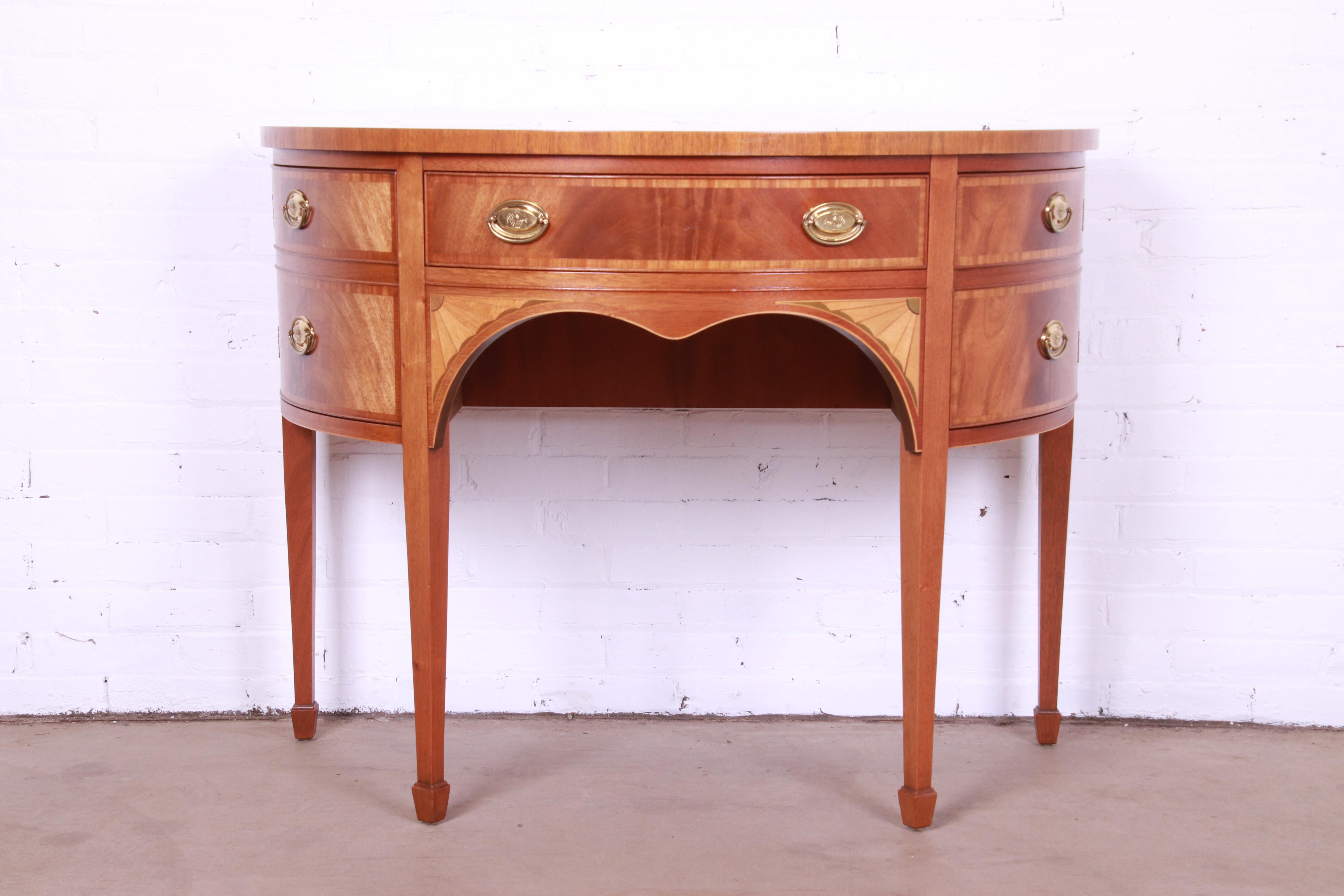 An exceptional Federal or Hepplewhite style demilune cabinet or sideboard

By Baker Furniture

USA, Circa 1980s

Flame mahogany, with satinwood banding and inlay and original brass hardware.

Measures: 45.25
