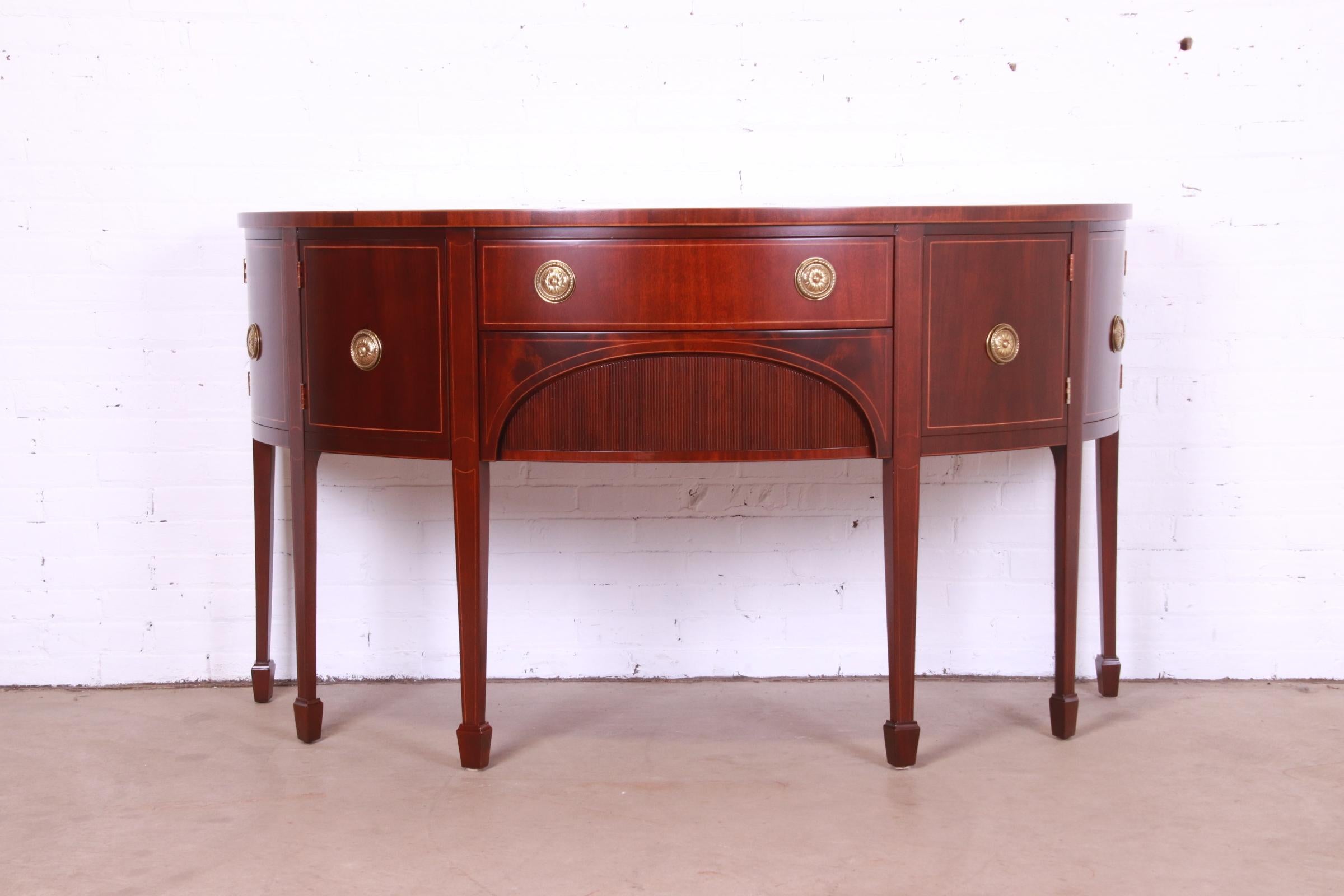 An exceptional Federal or Hepplewhite style demilune cabinet or sideboard

By Baker Furniture

USA, Circa 1980s

Mahogany, with satinwood string inlay, original brass hardware, and felt silverware insert.

Measures: 66