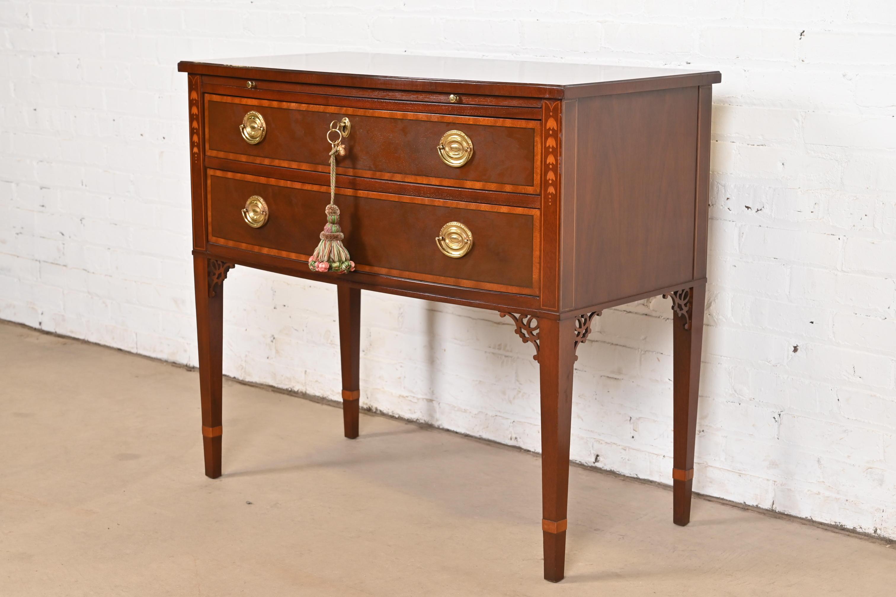 A gorgeous Federal or Hepplewhite style sideboard, buffet server, or console

By Baker Furniture

USA, Late 20th Century

Mahogany, with inlaid satinwood banding and marquetry, and original brass hardware. Top drawer locks, and key is