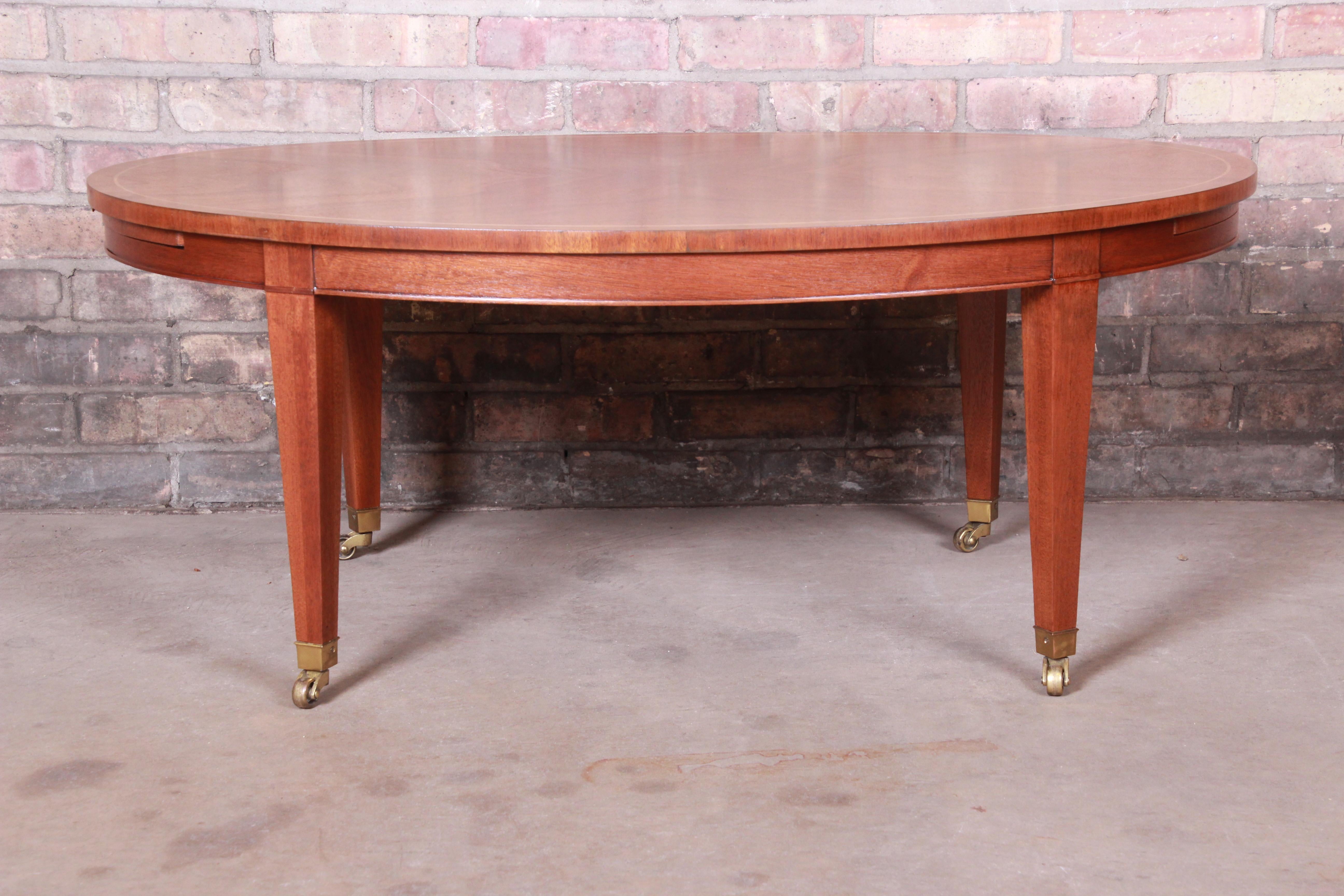 An exceptional Federal style coffee table with extension trays

By Baker Furniture

USA, circa 1980s

Book-matched mahogany, with brass accents and casters.

Measures: 41.75