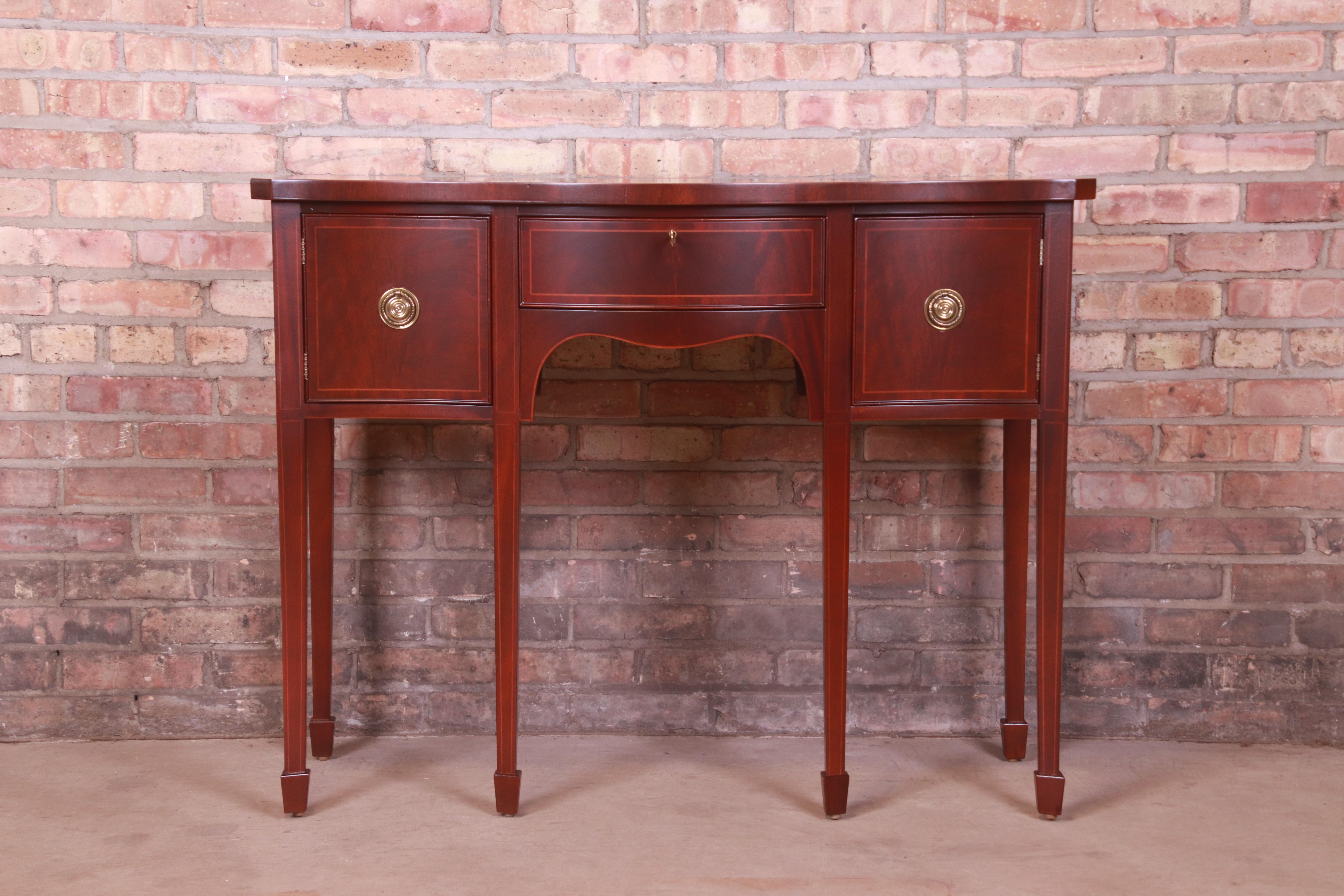 A gorgeous Federal or Hepplewhite style sideboard, credenza, or console

By Baker Furniture

USA, Circa 1980s

Mahogany, with satinwood string inlay and original brass hardware.

Measures: 42
