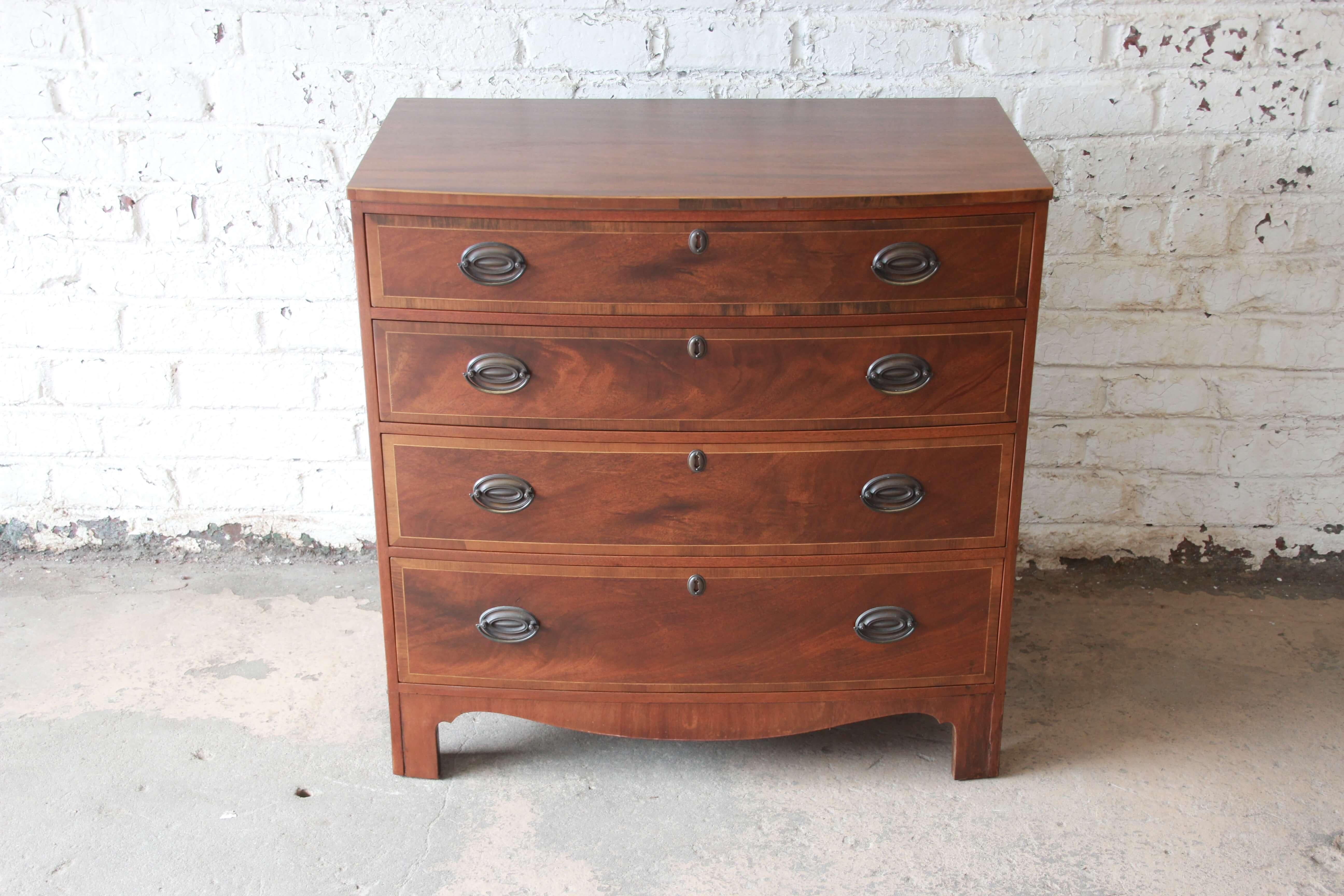 Offering a beautiful mahogany four-drawer chest of drawer by Baker Furniture. The chest display a stunning mahogany wood grain with four smooth sliding drawers. The dresser is a nice Georgian style and is in great vintage condition with minor wear