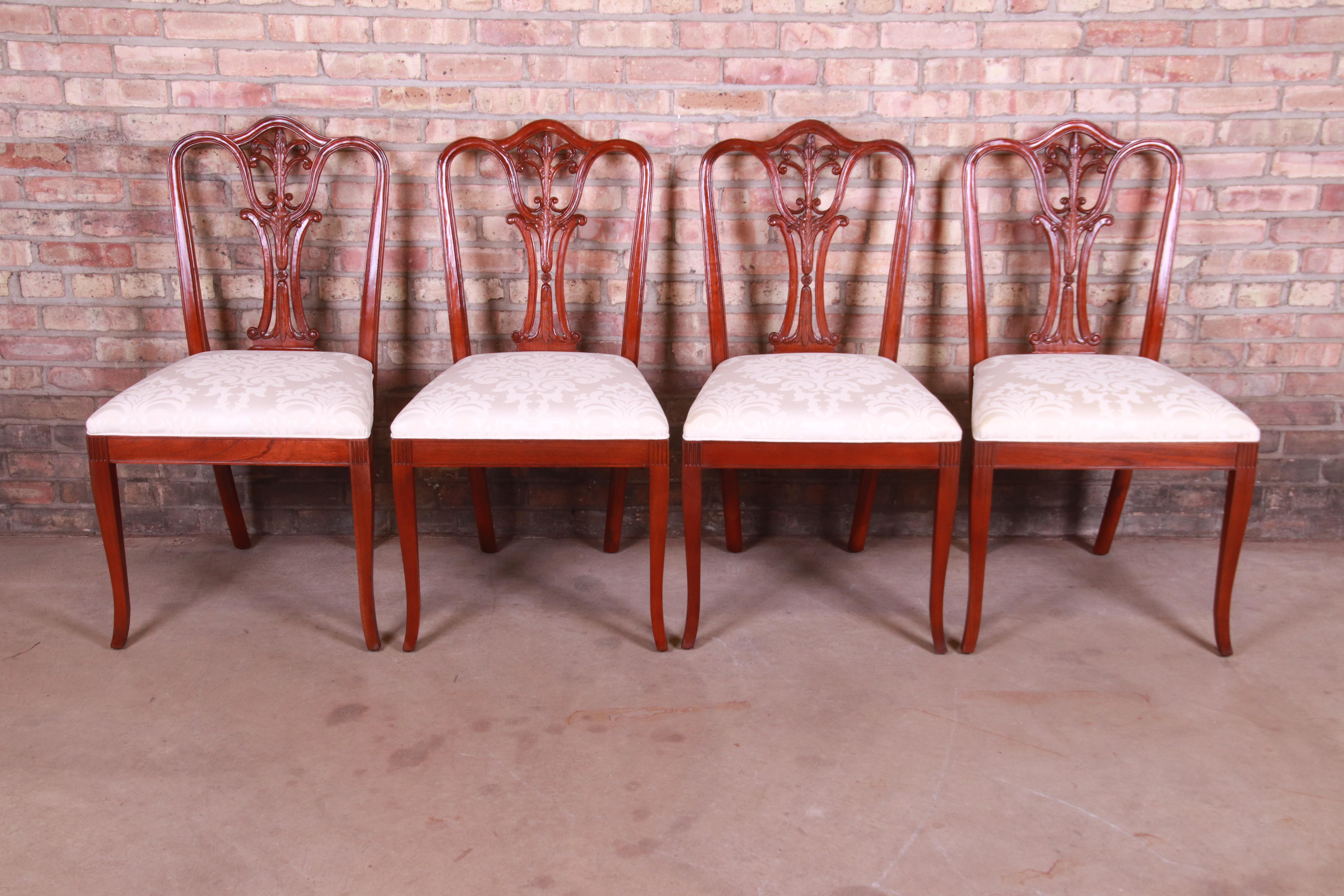 A gorgeous set of four French style carved mahogany dining chairs

By Baker Furniture

USA, circa 1980s

Solid carved mahogany frames, with damask ivory upholstered seats.

Measures: 21