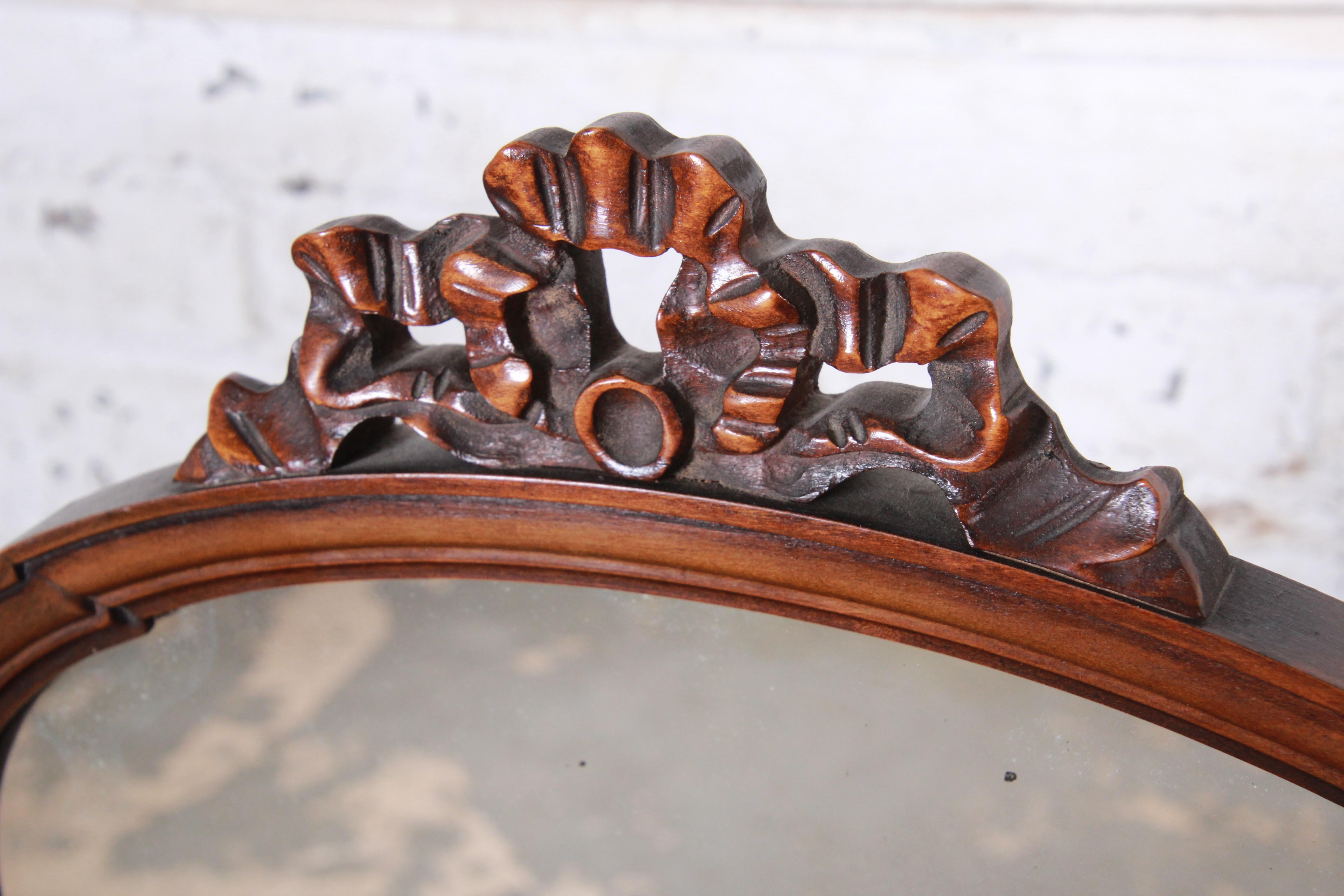 A gorgeous French Provincial carved mahogany dresser top vanity swing mirror

By Baker Furniture

USA, circa 1950s

Mahogany, brass and mirror

Measures: 25