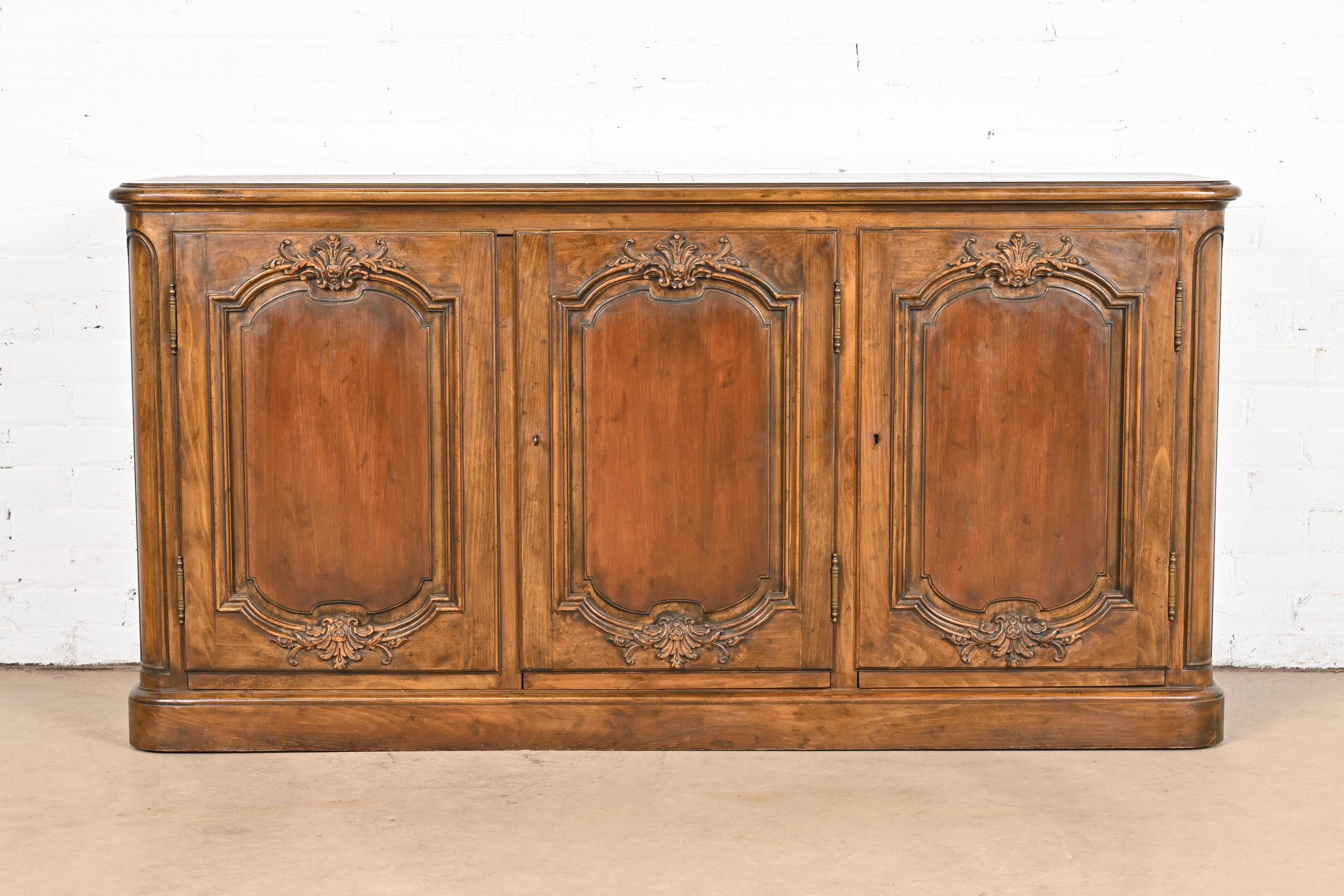 A gorgeous French Provincial Louis XV style carved walnut sideboard, credenza, or bar cabinet

By Baker Furniture

USA, Circa 1960s

Measures: 63.5