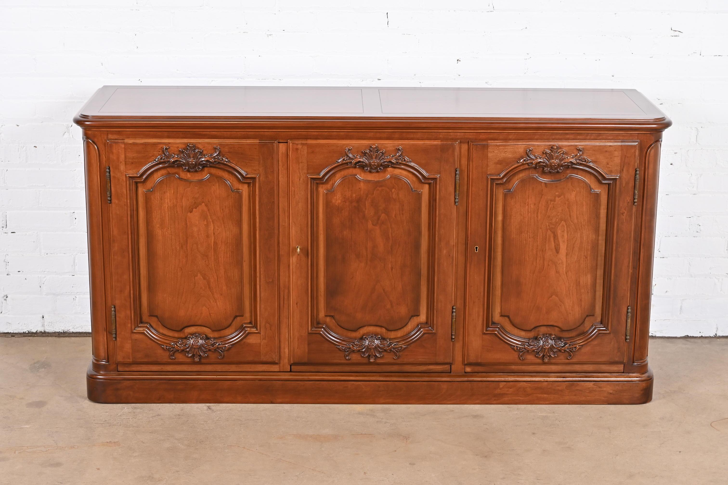 A gorgeous French Provincial carved cherry wood sideboard, credenza, or bar cabinet

By Baker Furniture

USA, Circa 1960s

Measures: 63