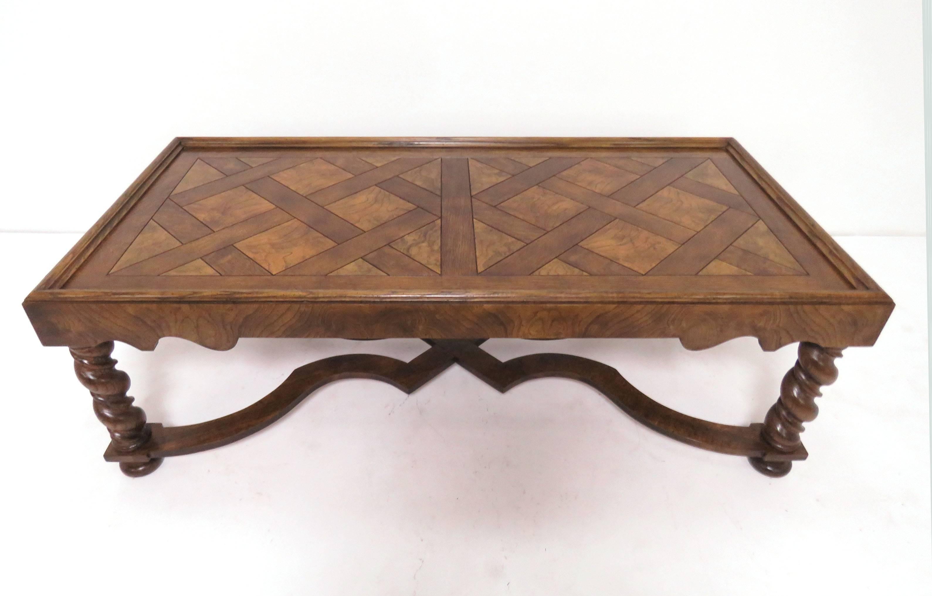 French country style coffee table by Baker Furniture, circa 1960s. Carved legs and saltire stretchers, parquet top in quartersawn oak contrasting with burl elements.