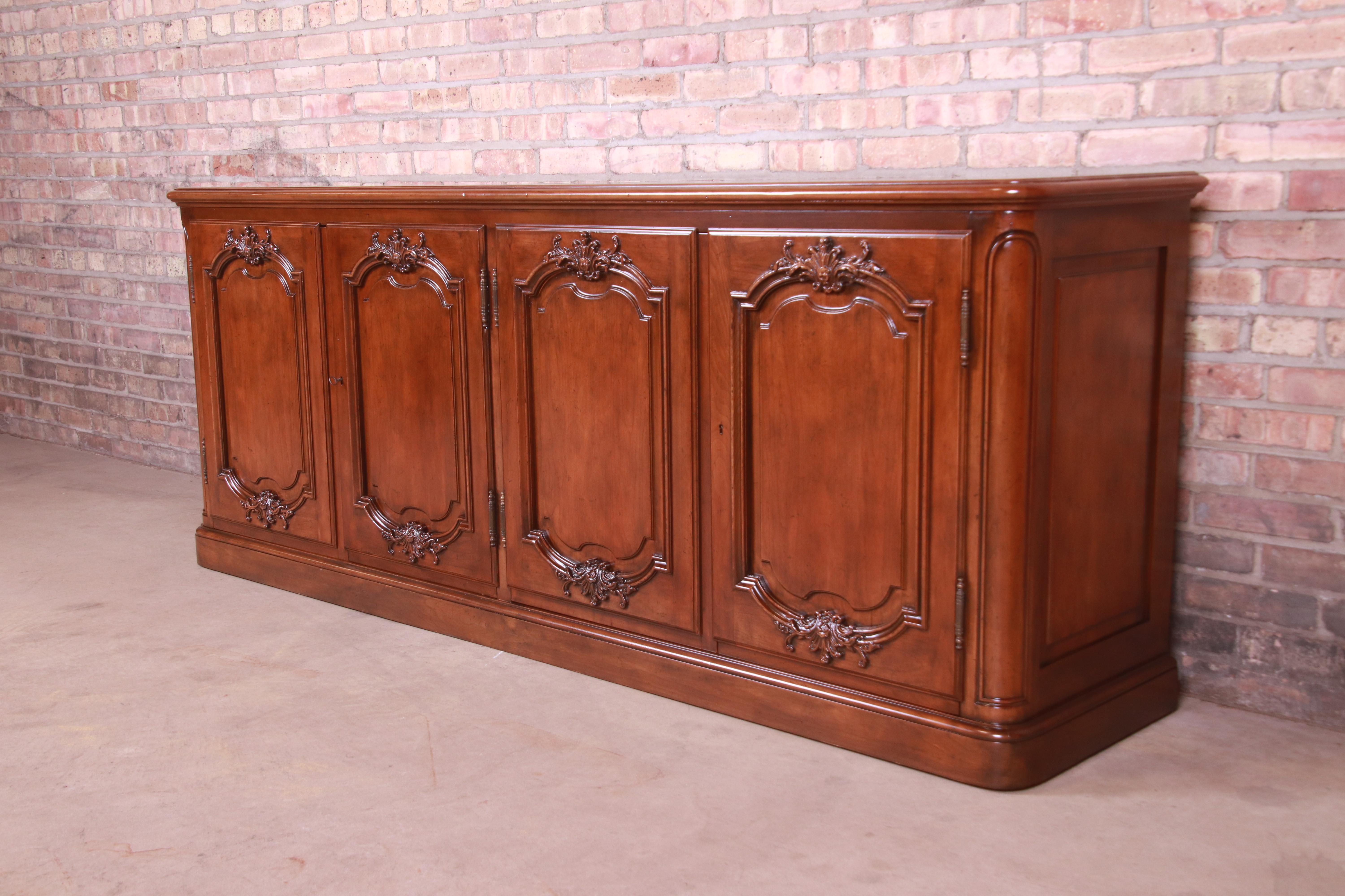 A gorgeous French Provincial carved walnut sideboard, credenza, or bar cabinet

By Baker Furniture 

USA, Circa 1960s

Measures: 82.75