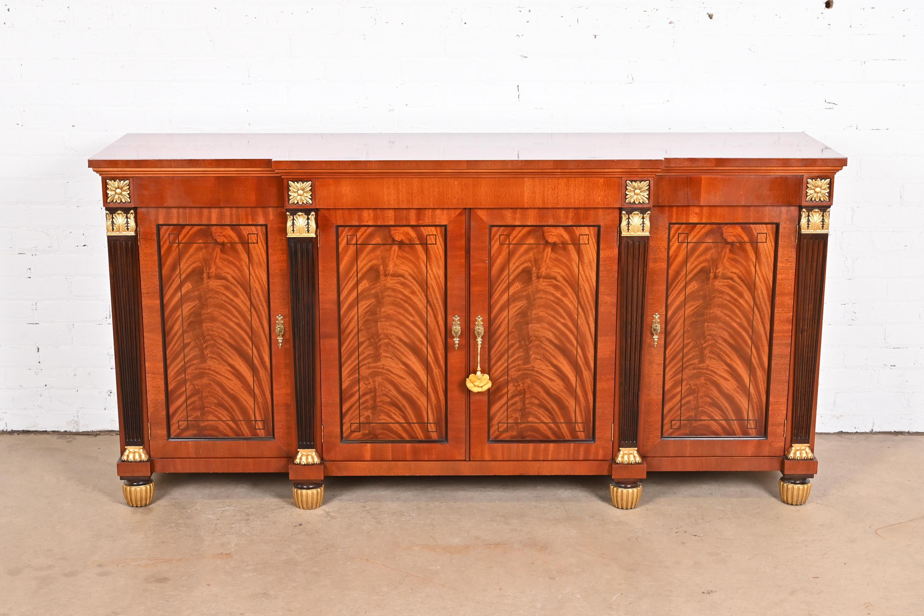 A gorgeous French Empire or French Regency Louis XVI style sideboard, credenza, or bar cabinet

By Baker Furniture

USA, Circa Late 20th Century

Stunning book-matched flame mahogany, with ebony inlay, gold gilt details, and original brass