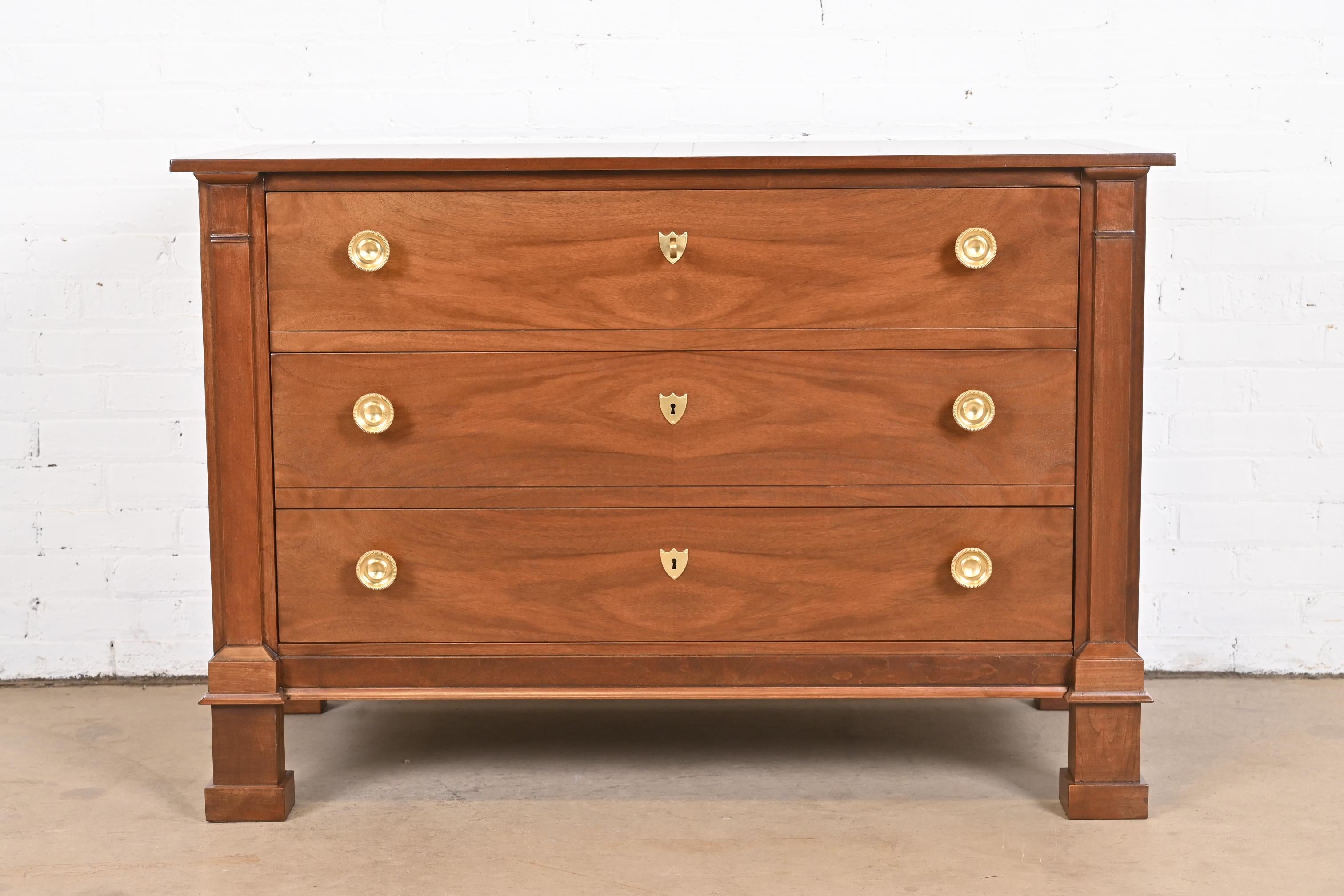 A beautiful Neoclassical or French Empire style three-drawer commode or chest of drawers

By Baker Furniture

USA, Circa 1980s

Gorgeous book-matched walnut, with burled walnut top and original brass hardware. Drawers lock, and key is