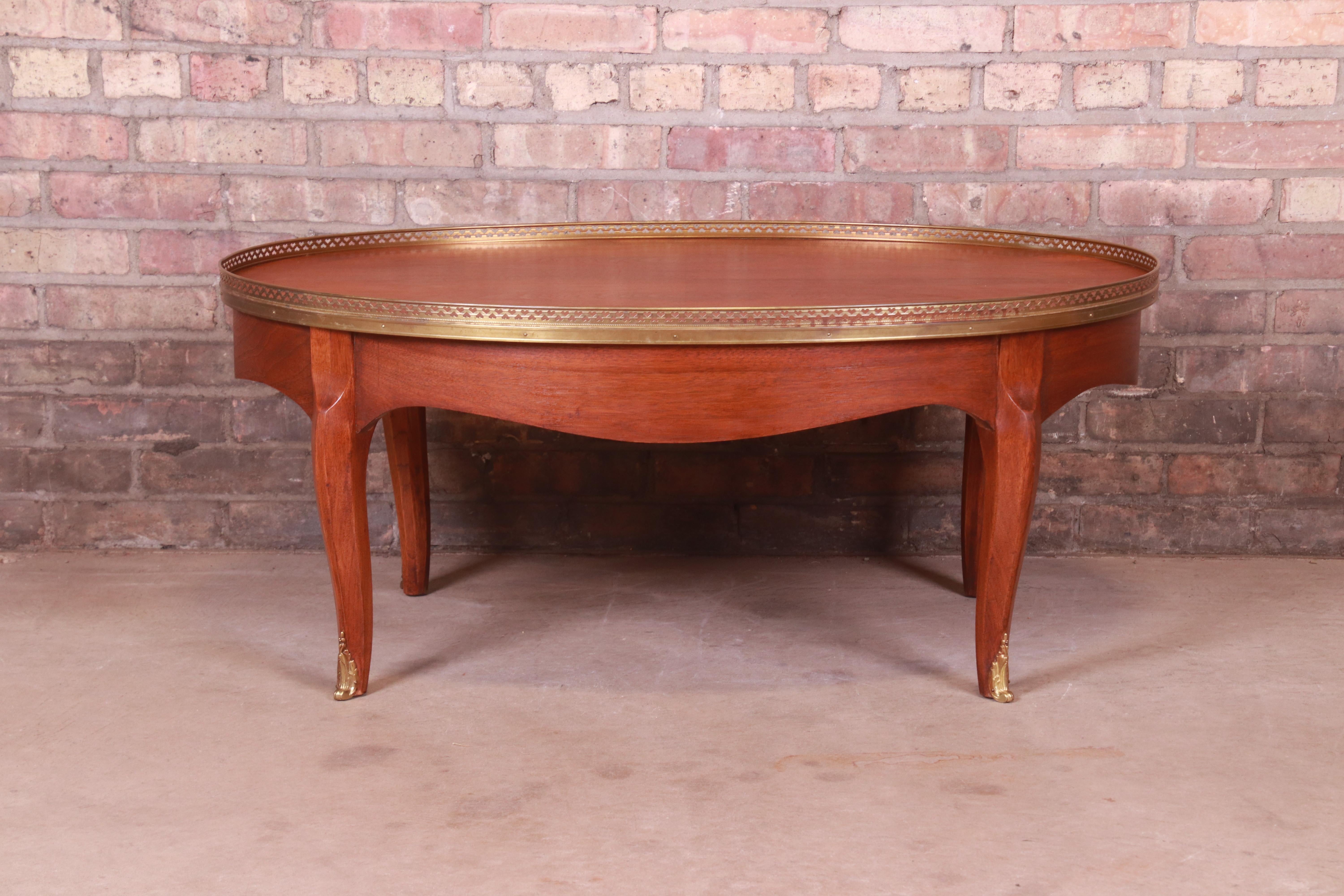 A gorgeous French Louis XV style coffee or cocktail table

By Baker Furniture

USA, Circa 1960s

Mahogany, with brass gallery and ormolu.

Measures: 40