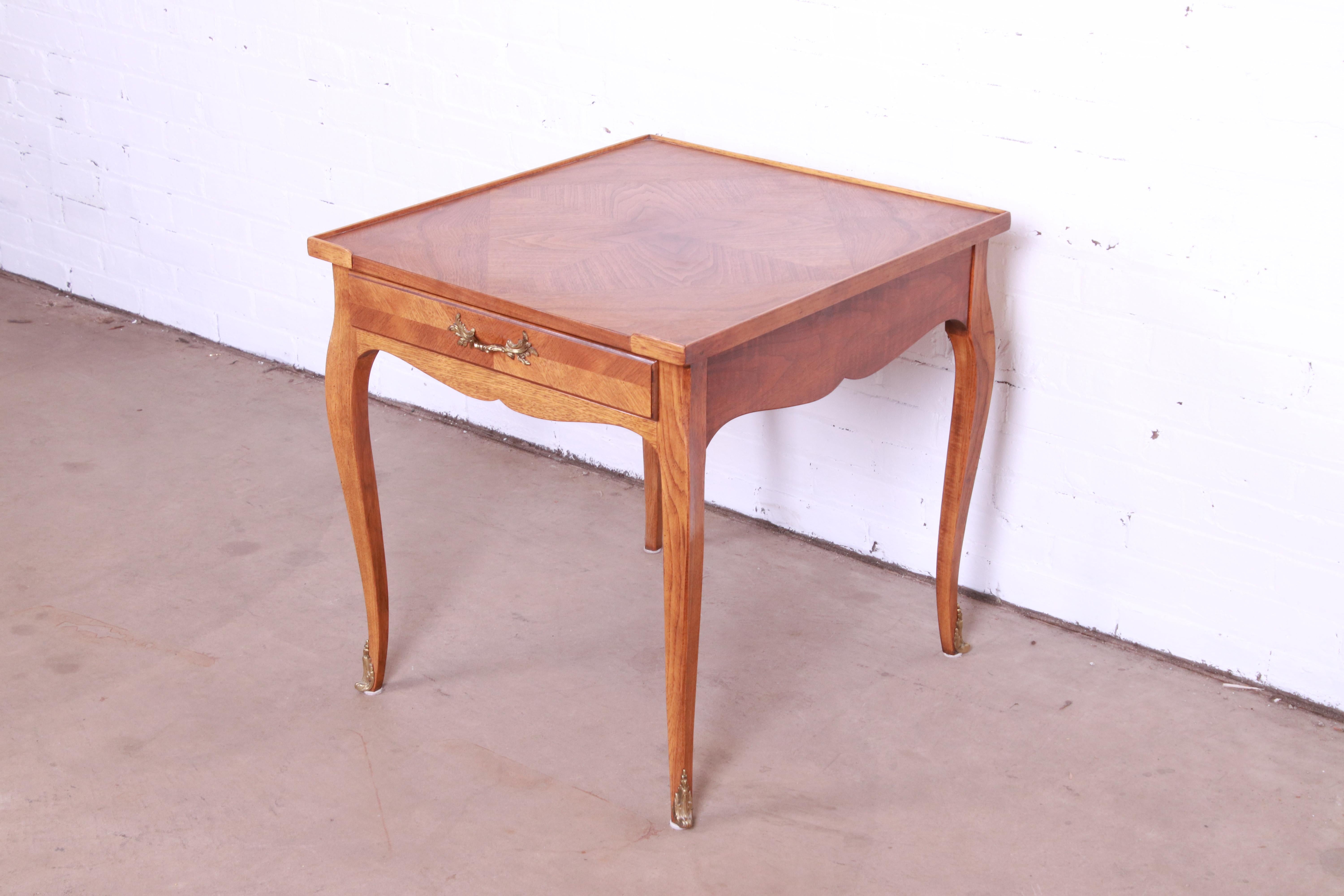 A beautiful French Louis XV style tea table or occasional side table

By Baker Furniture

USA, Circa 1960s

Gorgeous figured walnut, with original brass hardware.

Measures: 24
