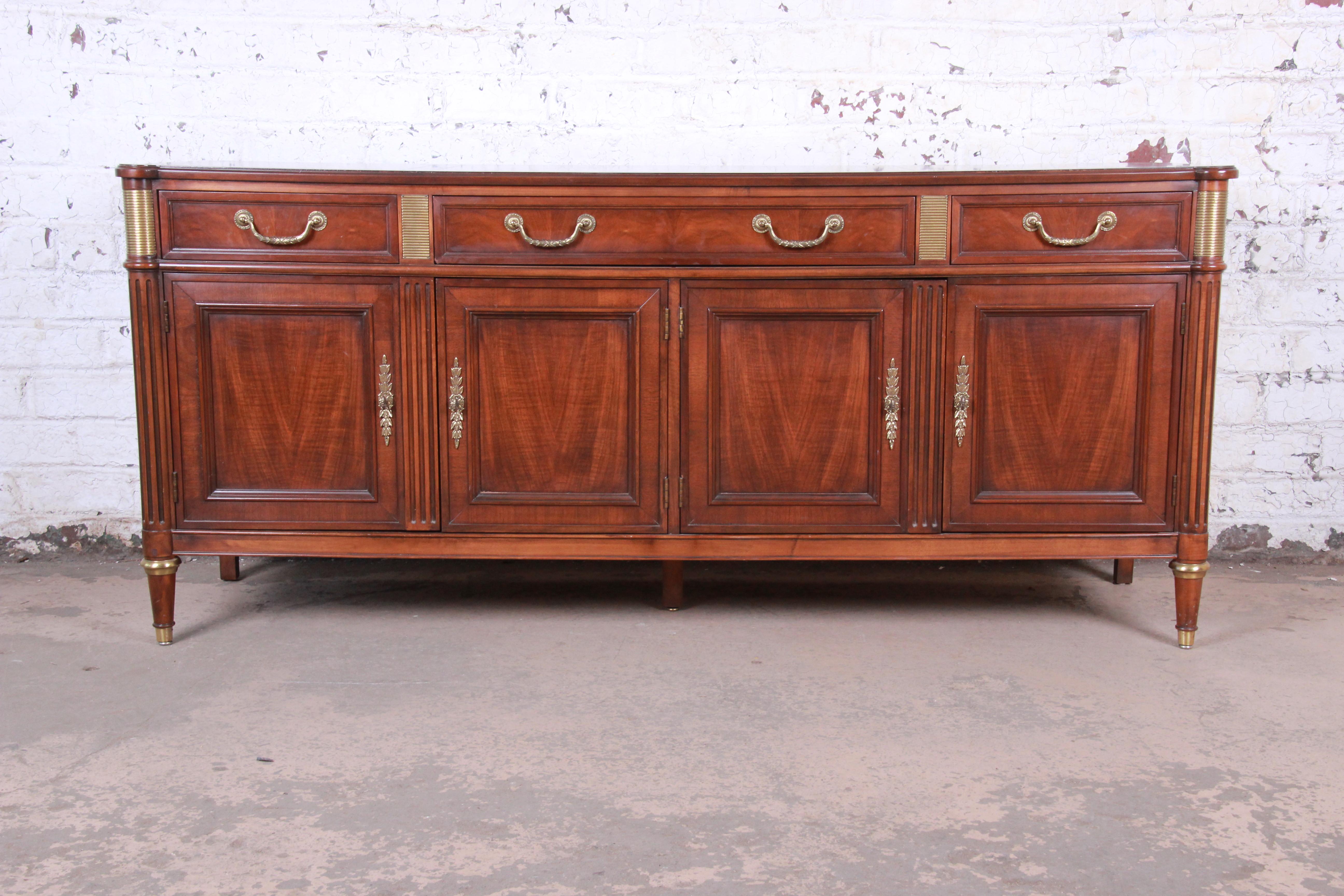 A gorgeous French Regency Louis XVI style sideboard credenza or bar cabinet

By Baker Furniture

USA, circa 1960s

Book-matched walnut, with brass trim and hardware.

Measures: 72.25