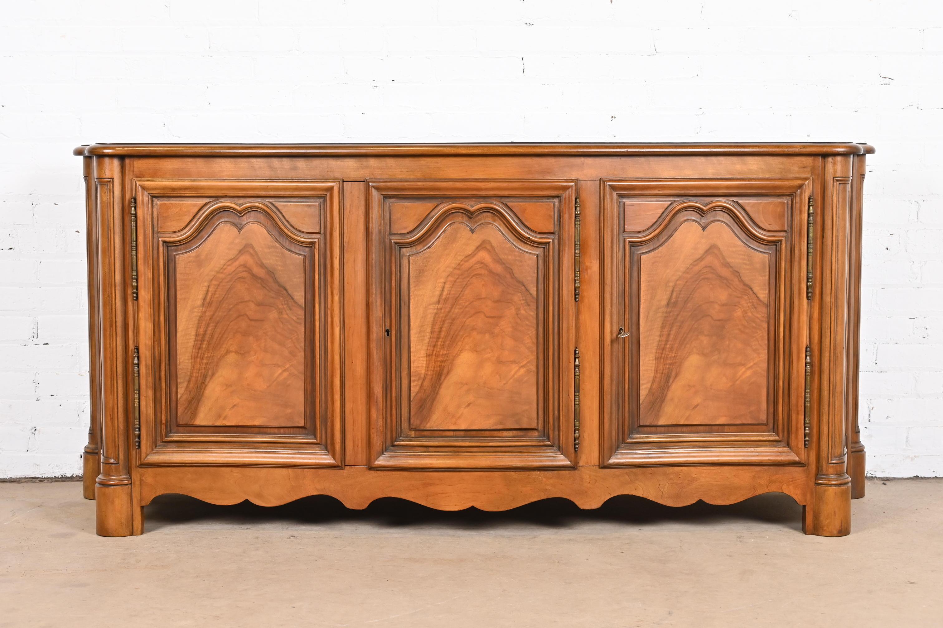 A gorgeous French Provincial or Louis Philippe style sideboard, credenza, or bar cabinet

By Baker Furniture

USA, Circa 1960s

Carved walnut, with book-matched burled walnut door fronts. Cabinets lock, and key is included.

Measures: 72