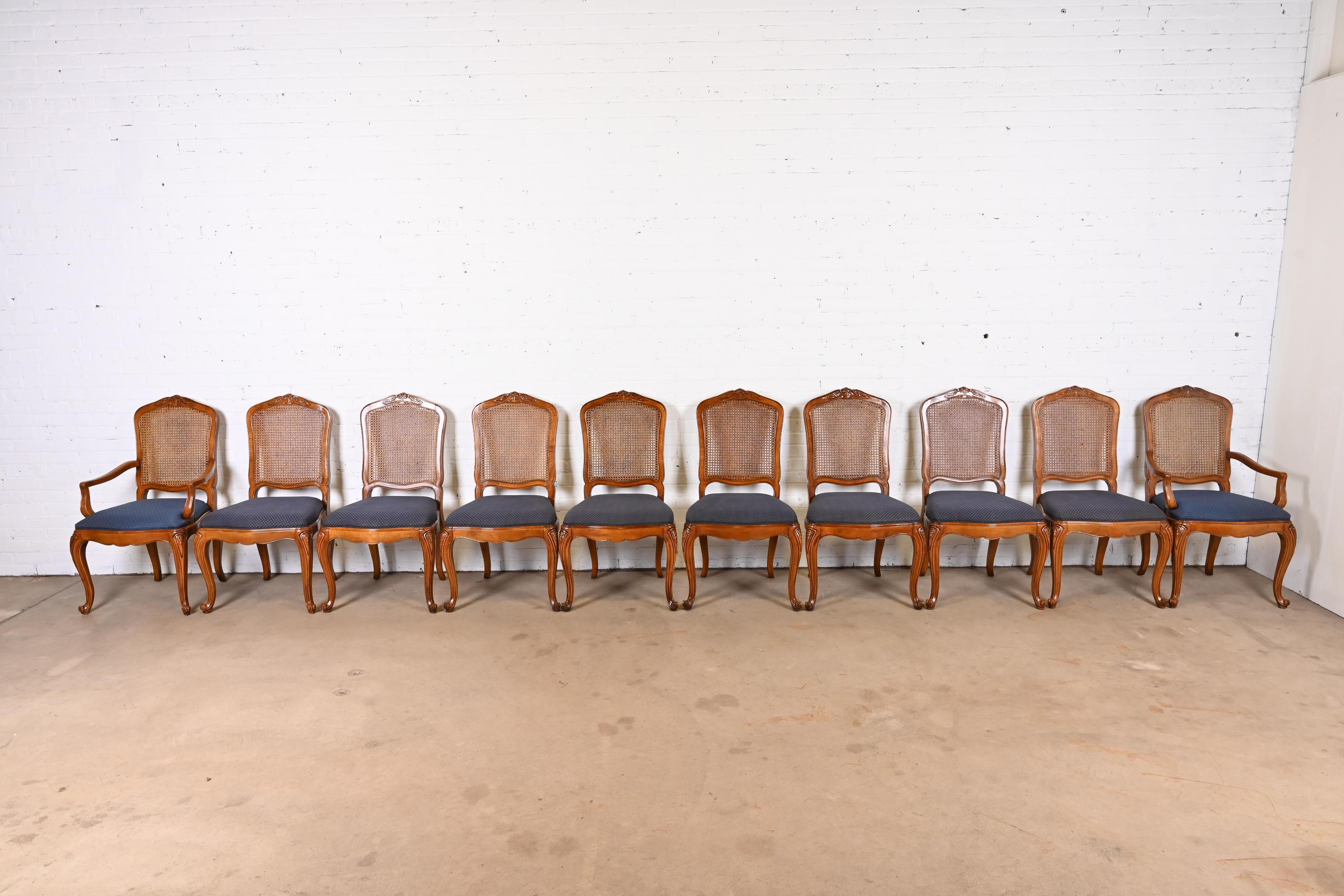 An outstanding set of ten French Provincial Louis XV style dining chairs

By Baker Furniture

USA, Circa 1980s

Solid carved cherry wood frames, with caned backs and upholstered seats.

Measures: 22