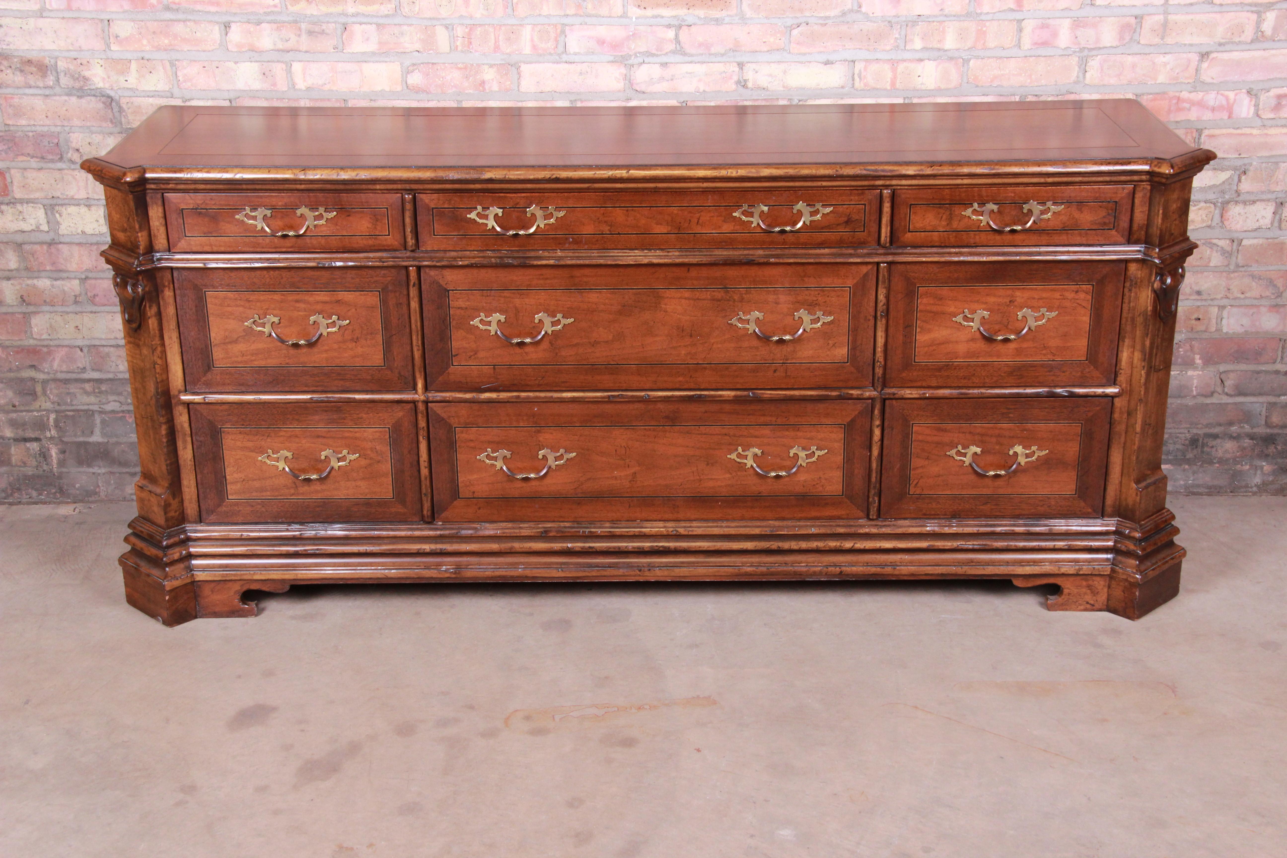 An exceptional French Provincial triple dresser or credenza

By Baker Furniture

USA, circa 1980s

Carved walnut, with original brass hardware.

Measures: 73.5