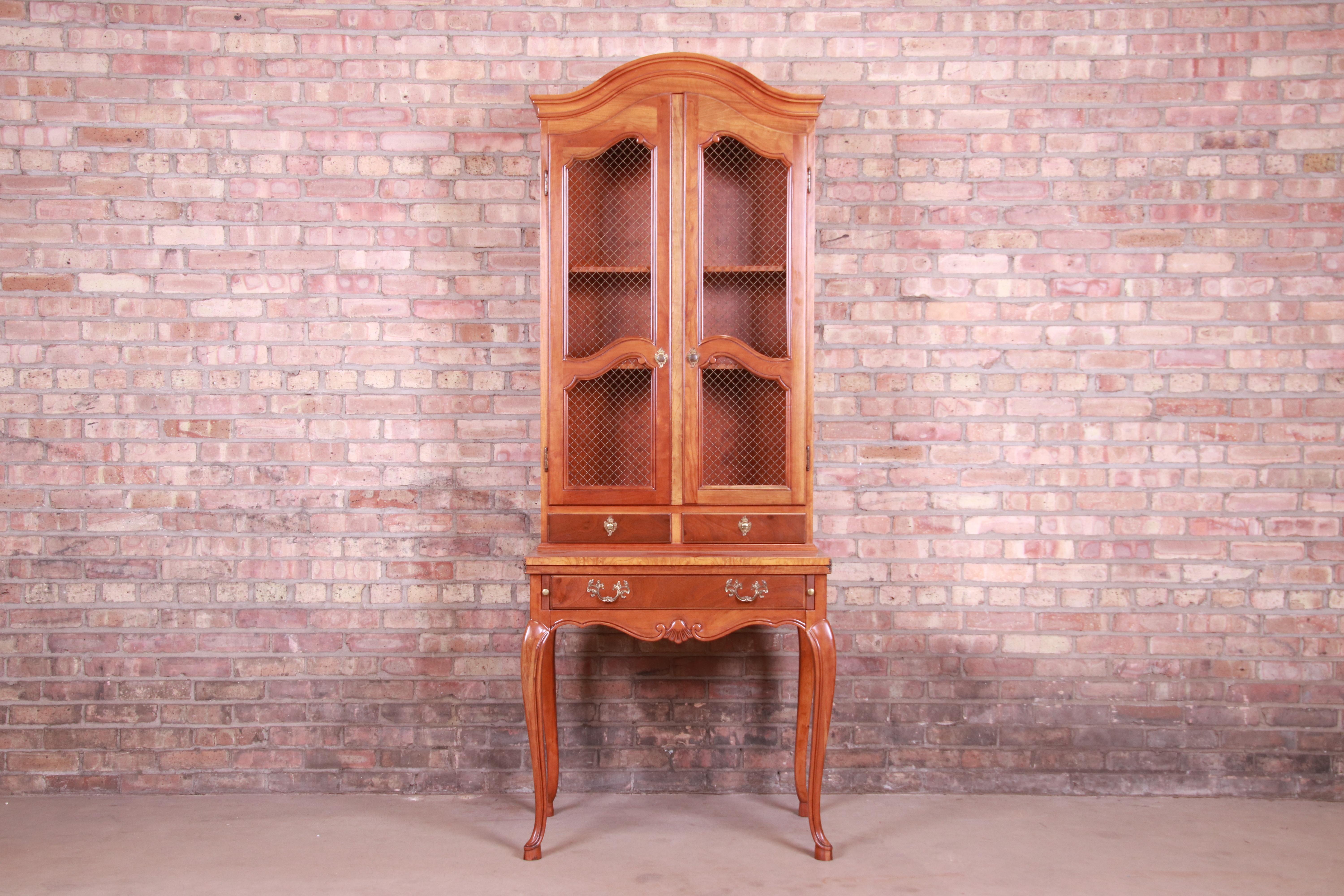 An exceptional French Provincial Louis XV style secretary desk with bookcase hutch

By Baker Furniture

USA, late 20th century

cherrywood, with burl wood trim and original brass hardware.

Measures: 30