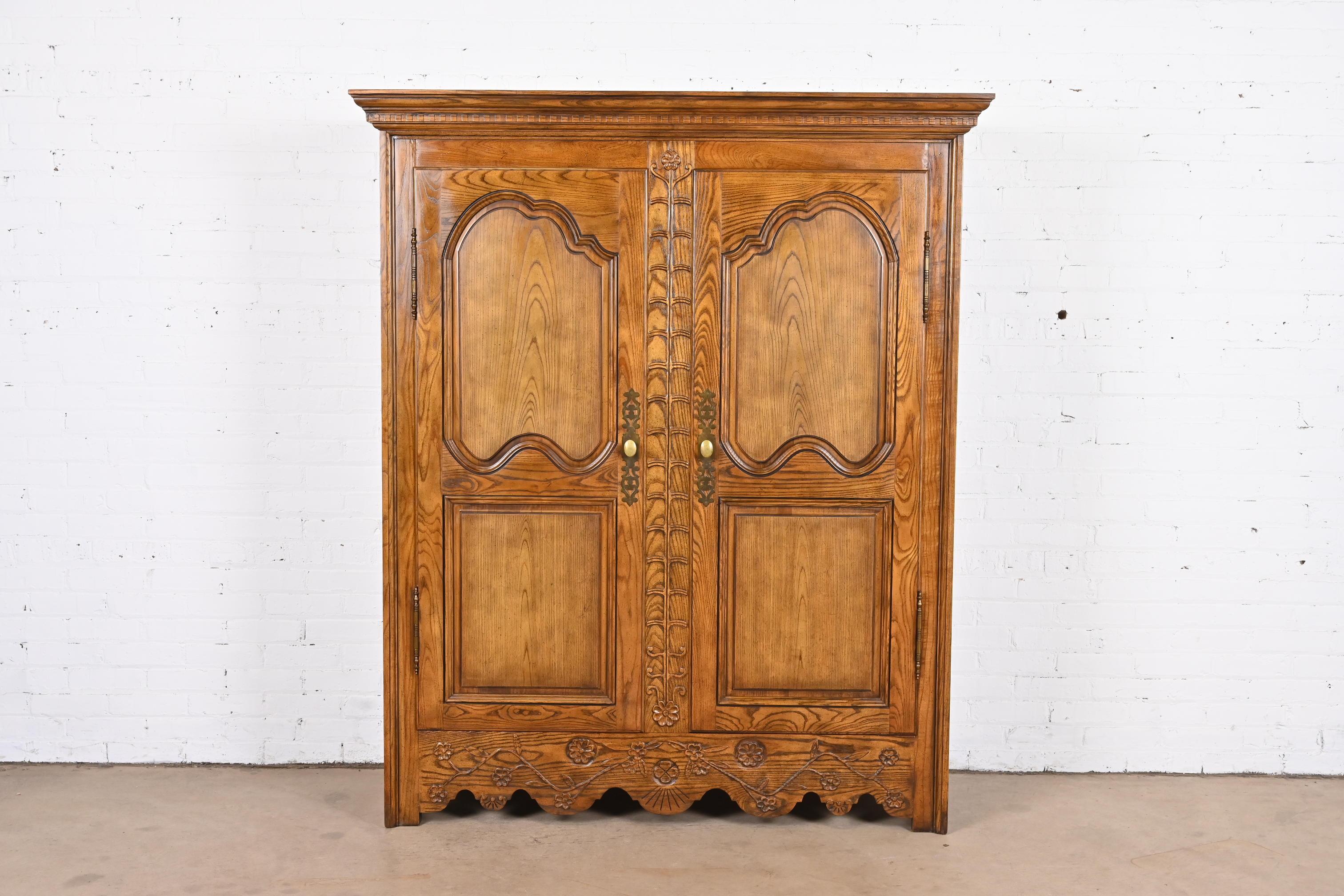 A gorgeous French Provincial Louis XV style armoire dresser or linen press

By Baker Furniture

USA, Circa 1960s

Beautiful carved oak, with original brass hardware.

Measures: 57.63