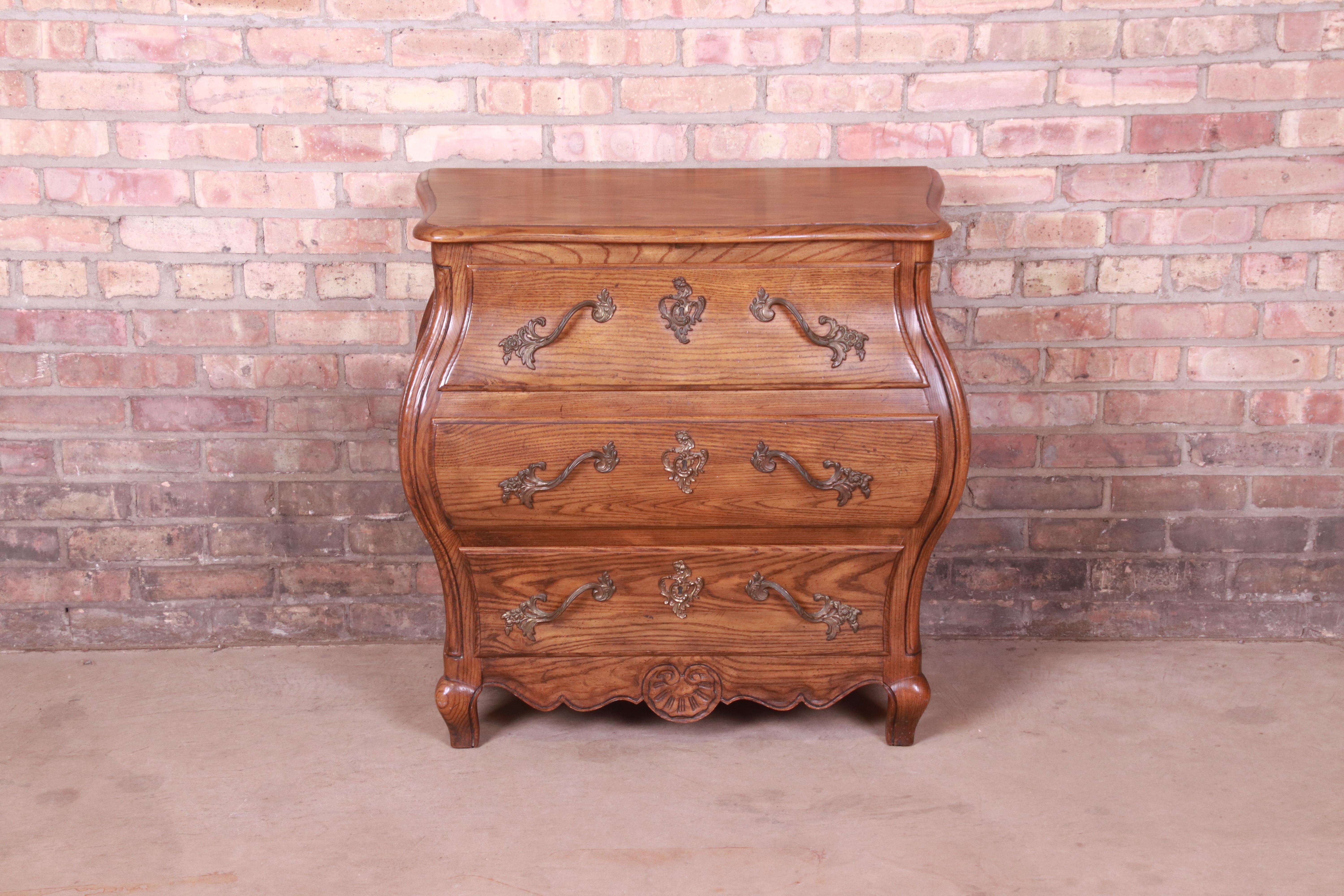 A beautiful French Provincial Louis XV style bombay form chest of drawers or commode

By Baker Furniture

USA, Circa 1980s

Carved oak, with original brass hardware.

Measures: 31