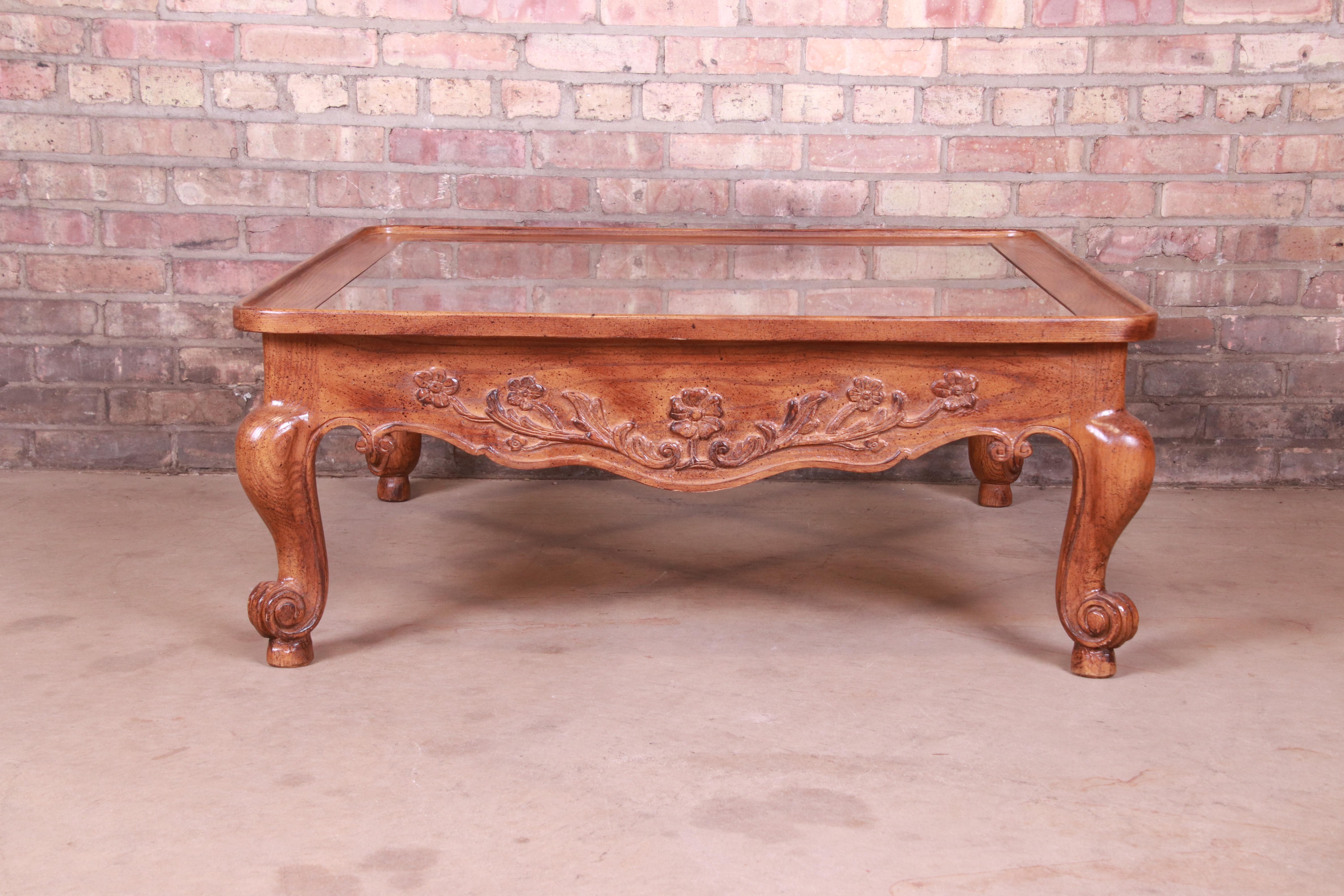 A gorgeous French Provincial Louis XV style coffee table

By Baker Furniture,

USA, Circa 1980s

Carved oak, with inset beveled glass top.

Measures: 39.25