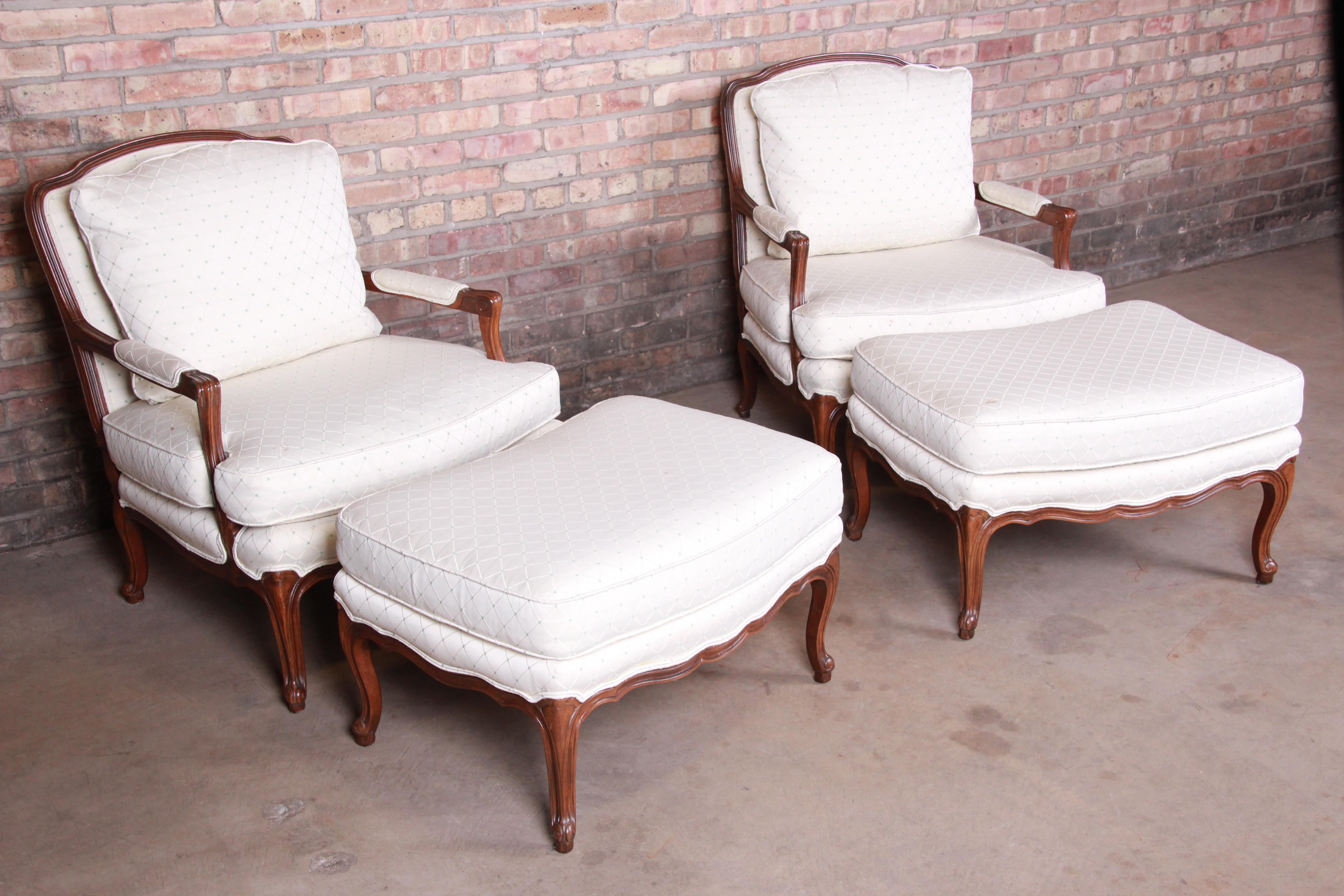 A gorgeous pair of French Provincial Louis XV bergère chairs with matching ottomans

By Baker Furniture

USA, 20th century

Carved walnut frames, with upholstered seats and backs.

Measures:
Chairs - 30