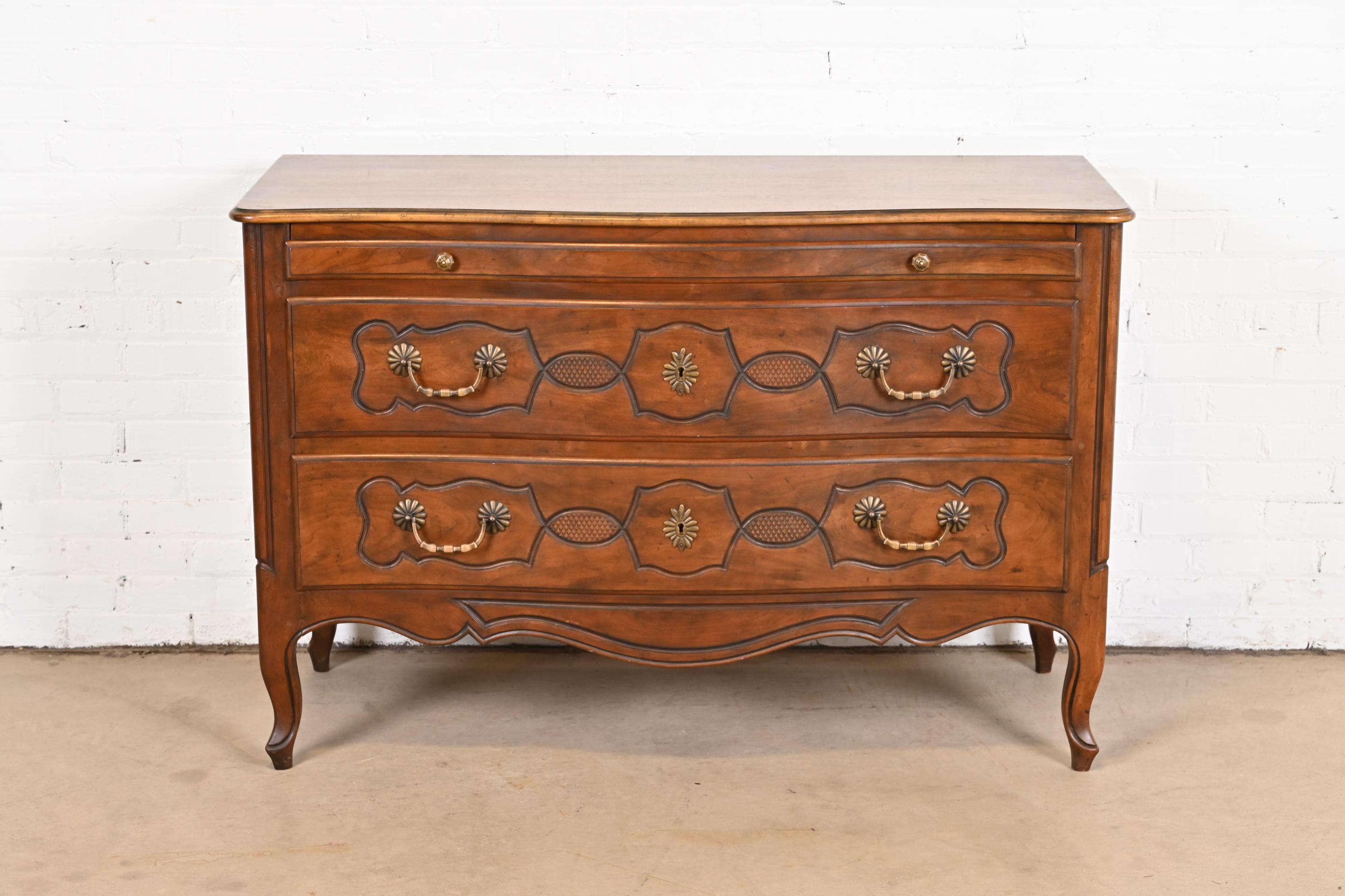 A gorgeous French Provincial Louis XV style commode, chest of drawers, or server

By Baker Furniture

USA, circa 1960s

Carved walnut, with original brass hardware.

Measures: 51.25