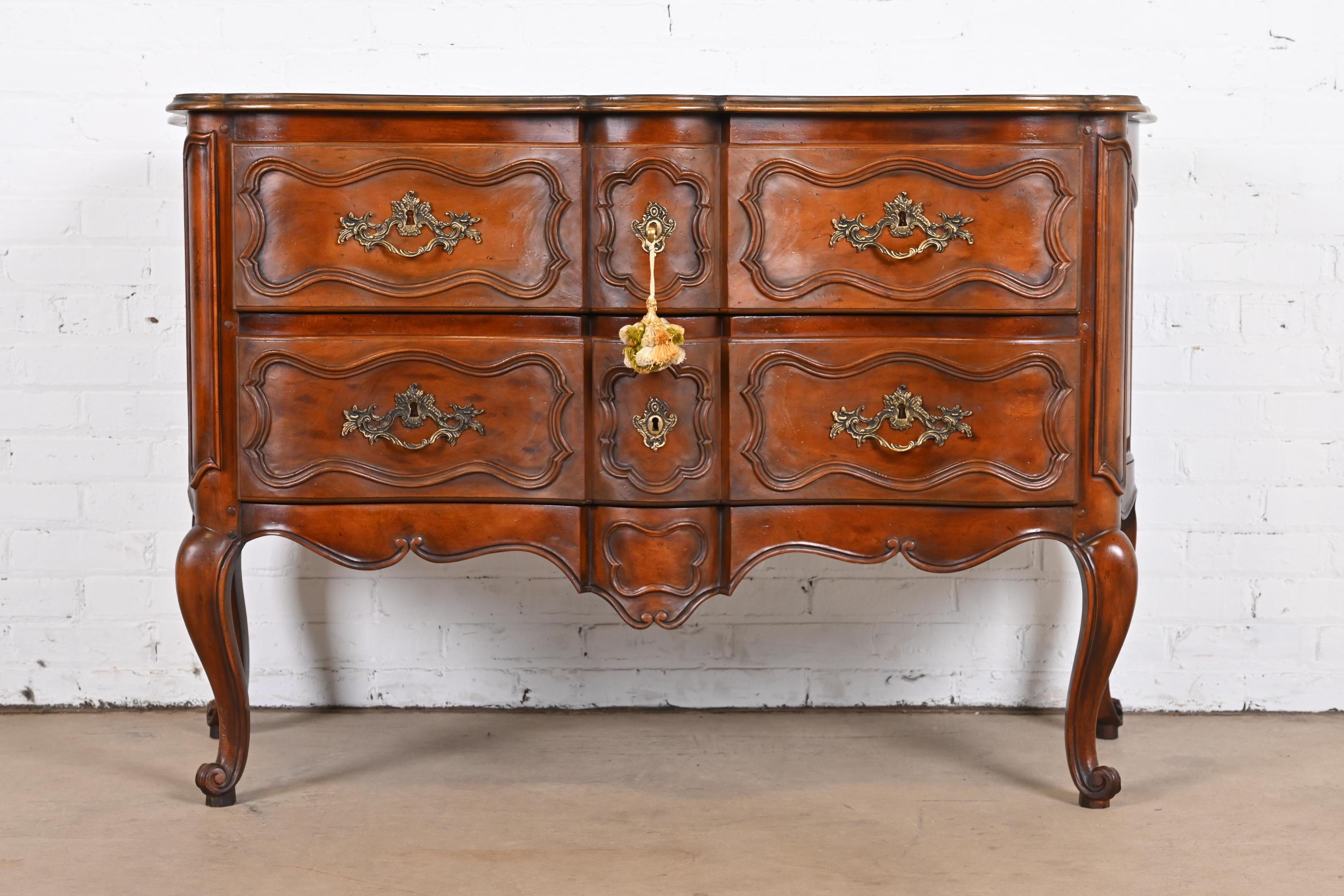 A gorgeous French Provincial Louis XV style commode, dresser chest, or sideboard

By Baker Furniture

USA, Circa 1960s

Carved walnut, with original brass hardware. Original key is included.

Measures: 52