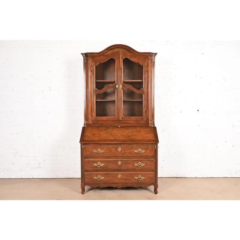 Uno splendido scrittoio in stile Luigi XV francese con scrivania a ribalta e piano libreria a conchiglia

Da Baker Furniture

USA, circa anni '1980

Noce intagliato, con ferramenta originale in ottone e piano di scrittura in pelle. Il mobile si