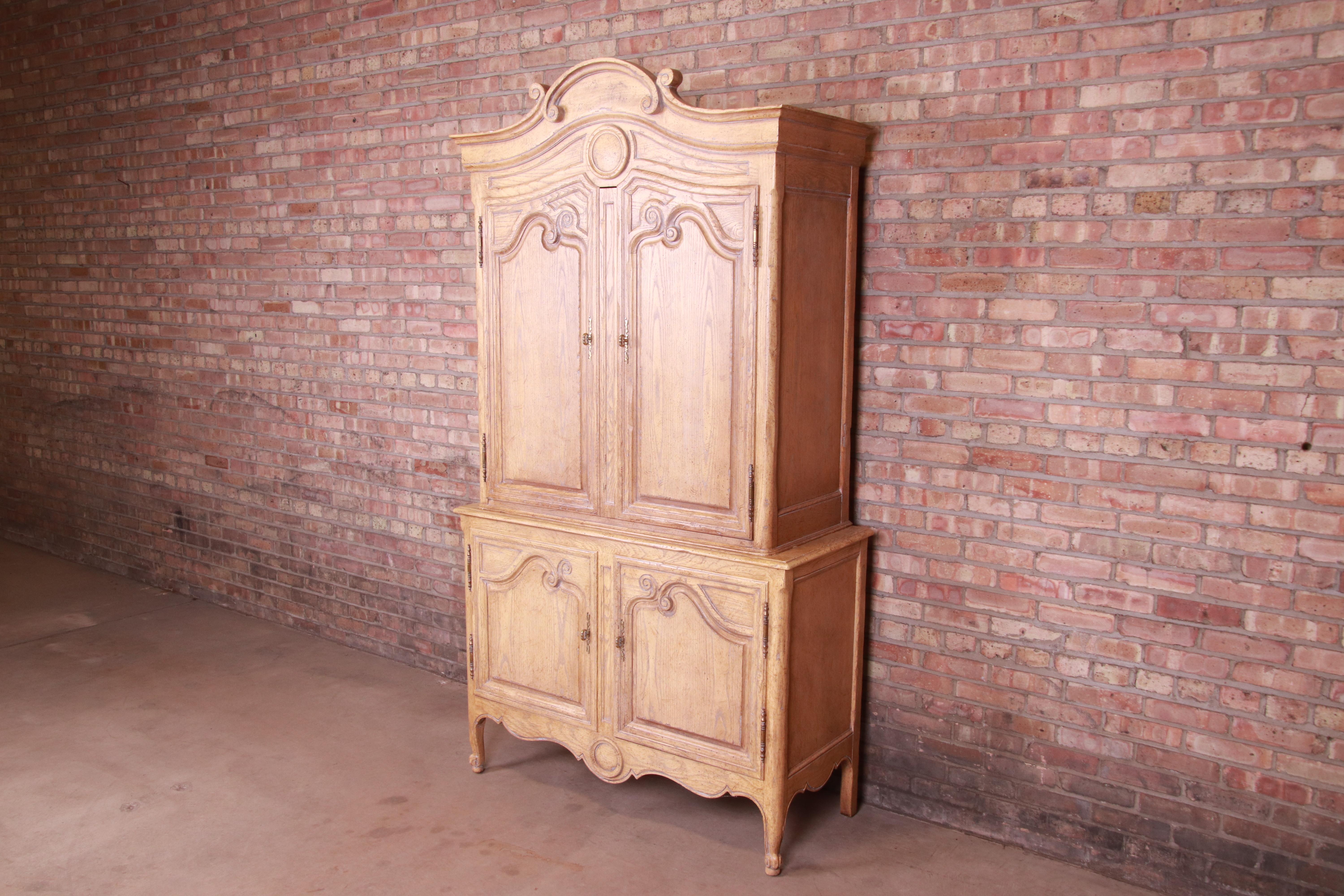 A gorgeous French Provincial Louis XV style armoire dresser or gentleman's chest

By Baker Furniture

USA, circa 1960s

Carved white oak, with brass hardware.

Measures: 48