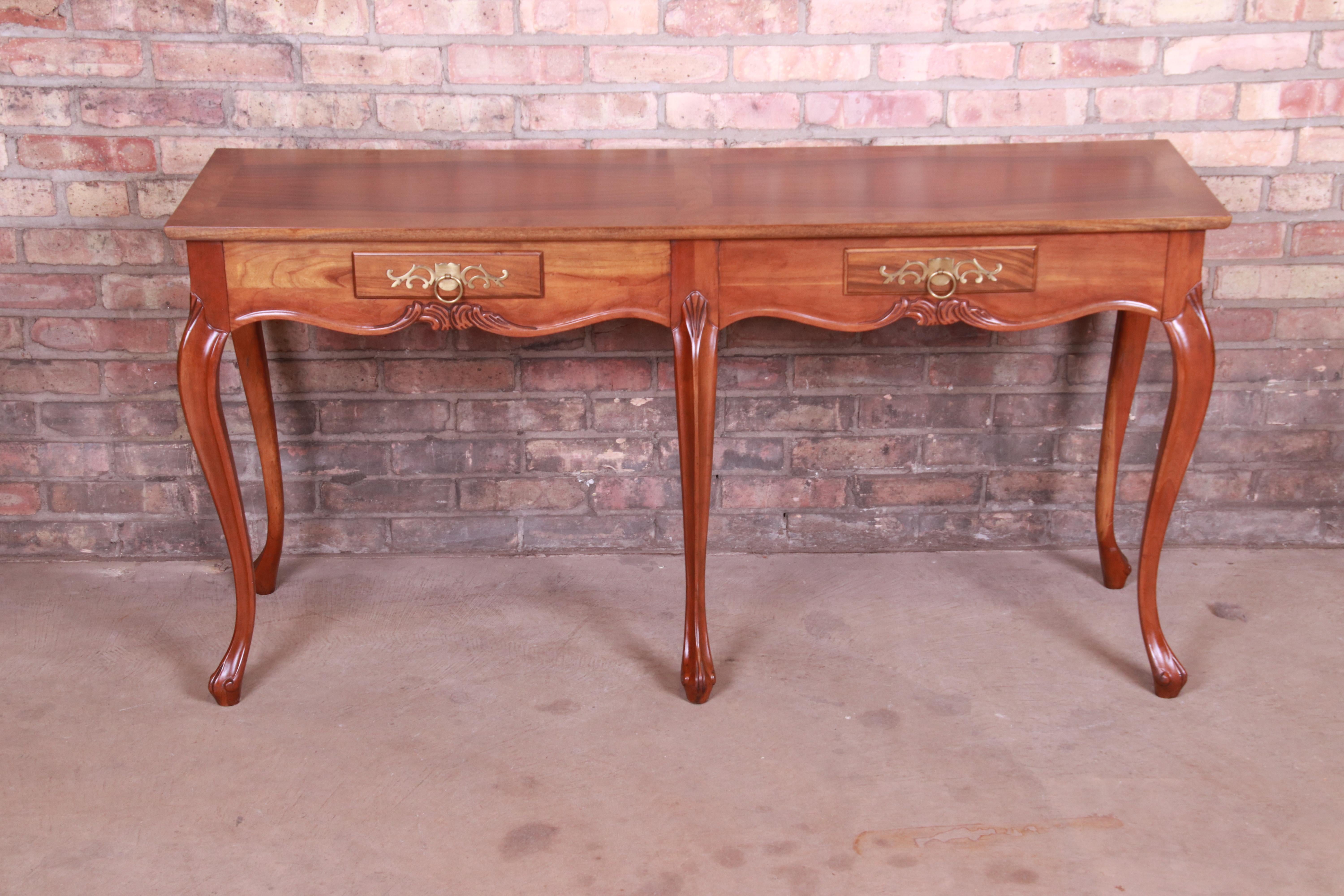 An exceptional French Provincial Louis XV style console, sofa table, or entry table

By Baker Furniture

USA, circa 1980s

Cherrywood, with inlaid walnut and banded burl wood top and original brass hardware.

Measures: 54