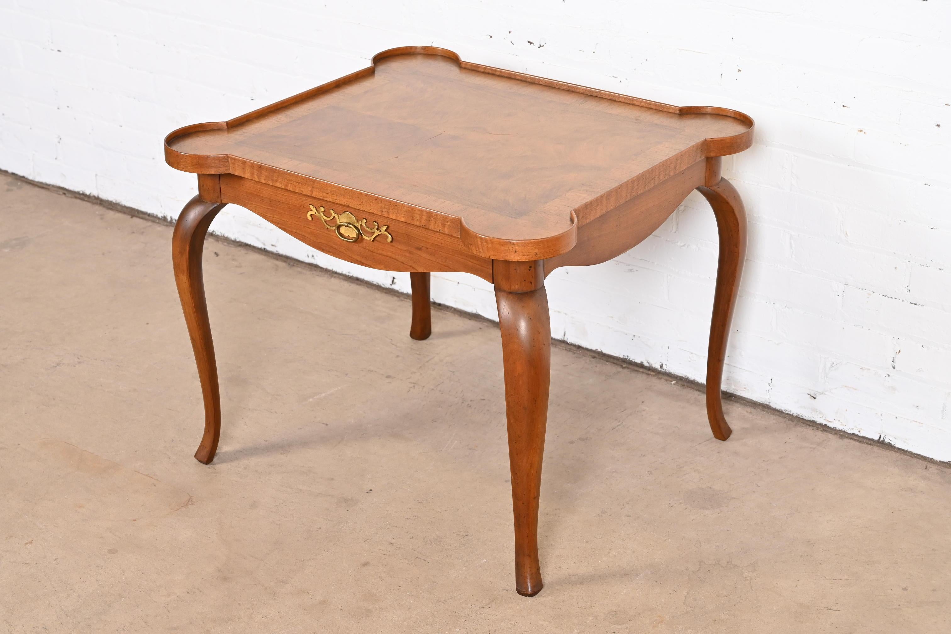 Ein wunderschöner Nachttisch mit einer Schublade im Louis XV-Stil, Teetisch oder Beistelltisch

Von Baker Furniture

USA, ca. 1960er Jahre
Kirschbaumholz, mit gebänderter Wurzelholzplatte und originalen Messingbeschlägen.

Maße: 28.5 