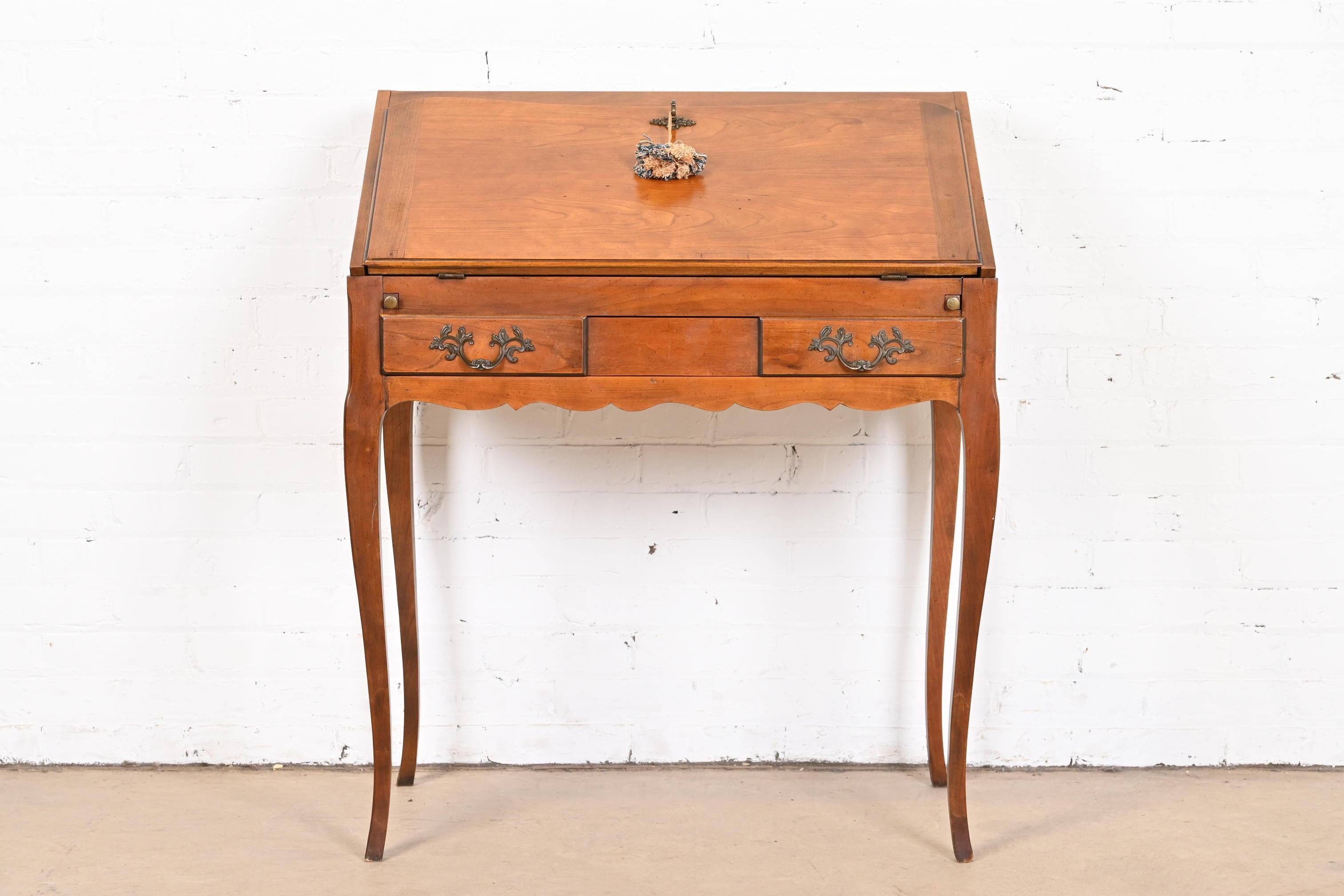 A gorgeous petite French Provincial Louis XV style slant front writing desk or secretary desk

USA, circa 1960s

Beautiful cherry wood, with original brass hardware.

Desk measures: 31.75