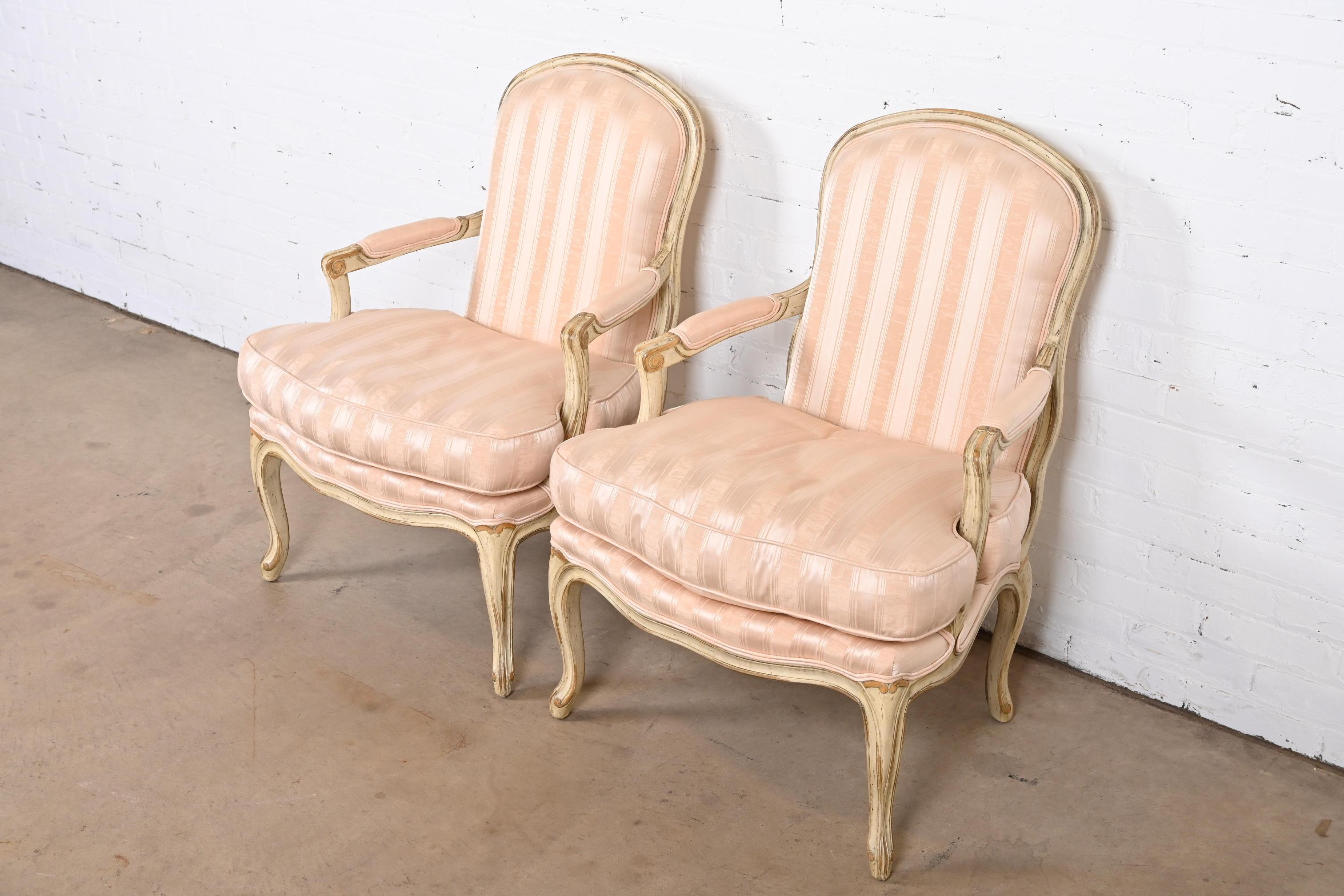 Une superbe paire de chaises longues tapissées de style Louis XV, de style provincial français.

Par Baker Furniture

États-Unis, fin du 20e siècle

Cadres en noyer peint sculpté, avec sièges et dossiers rembourrés à rayures roses.

Mesures