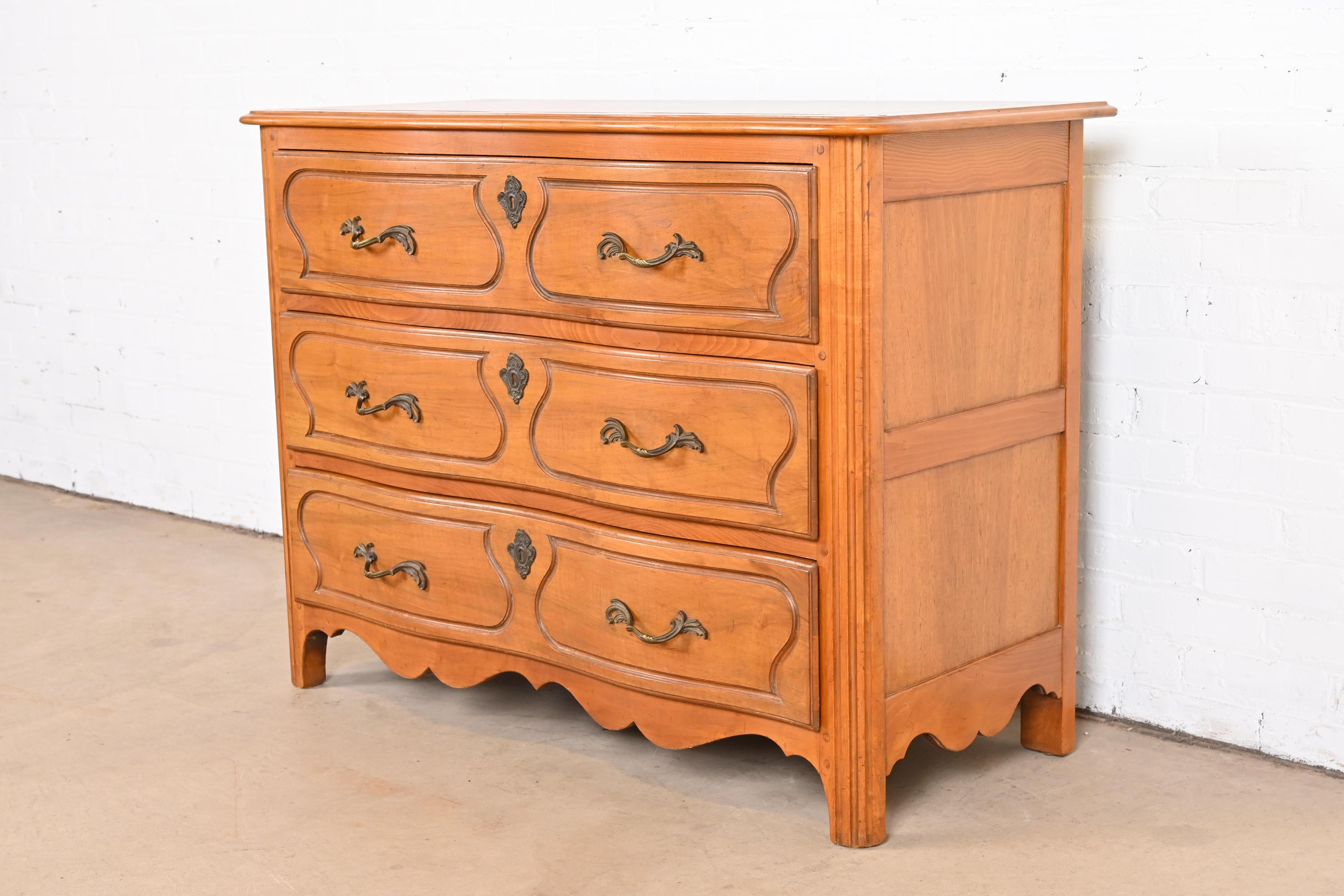 A gorgeous French Provincial Louis XV style dresser or chest of drawers

By Baker Furniture

USA, circa 1940s

Sculpted maple, with walnut top and original brass hardware.

Measures: 45.25