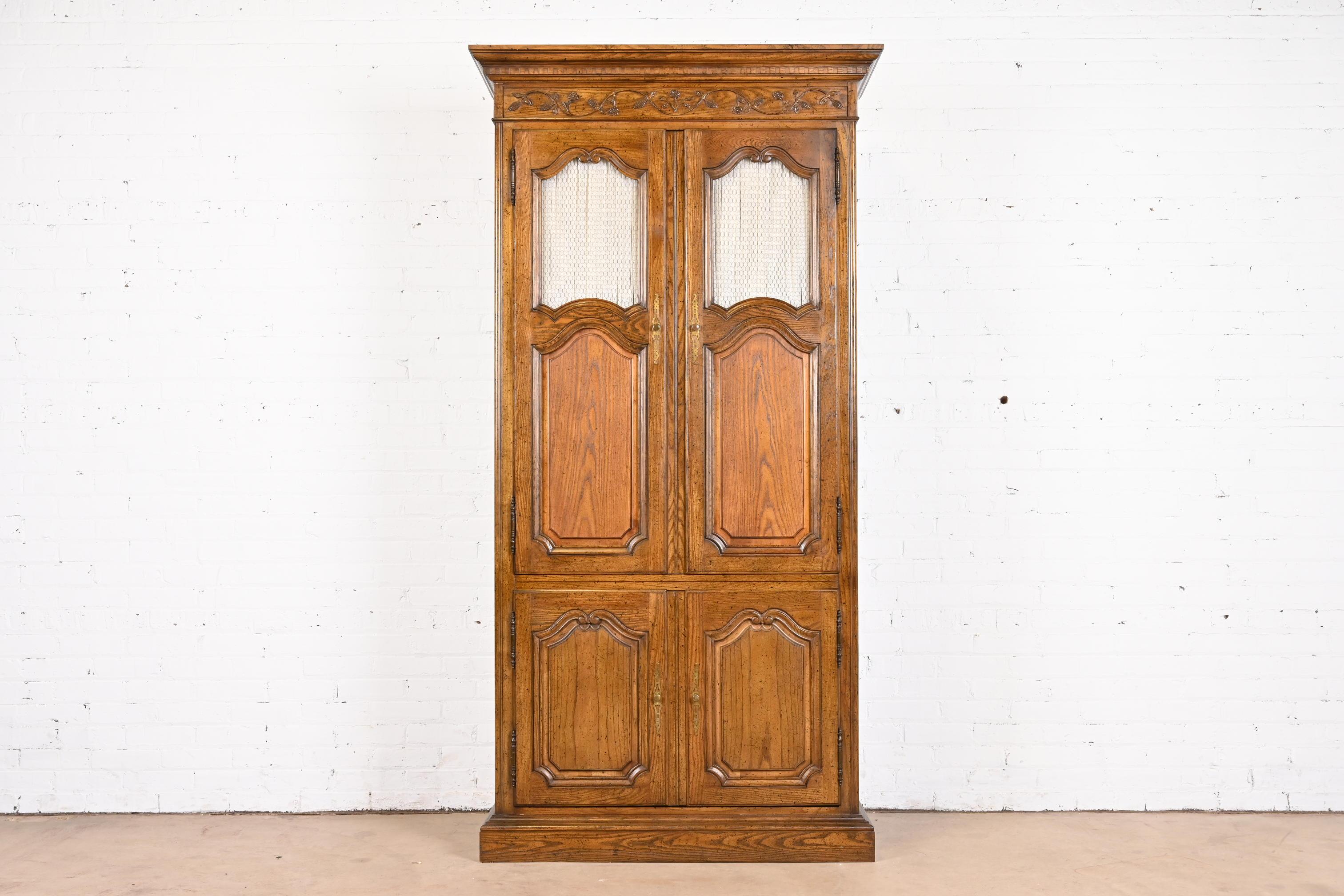 A gorgeous French Provincial Louis XV style armoire dresser or linen press

By Baker Furniture

USA, Circa 1960s

Carved oak, with original brass hardware.

Measures: 42.75