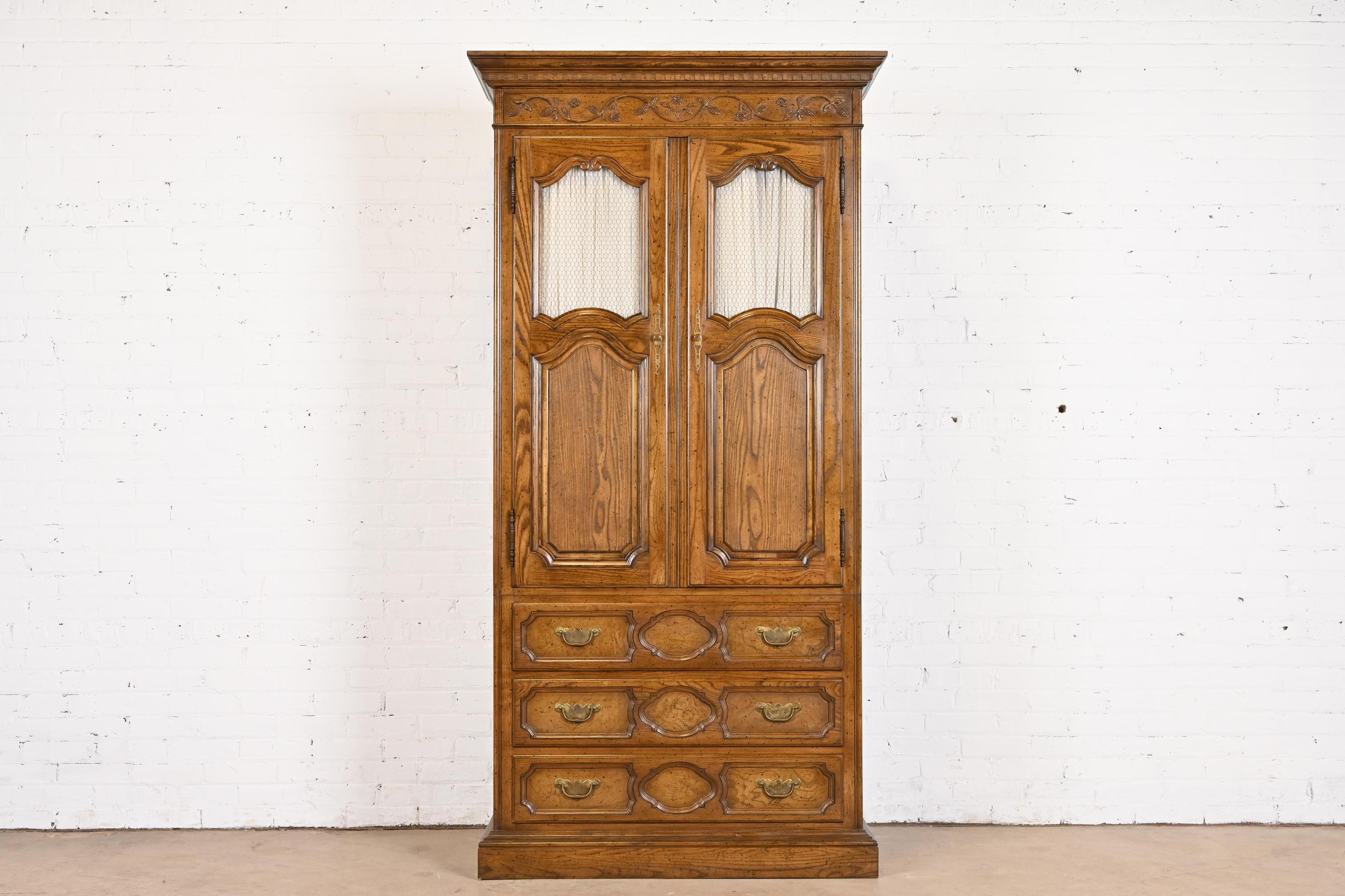 A gorgeous French Provincial Louis XV style armoire dresser or linen press

By Baker Furniture

USA, Circa 1960s

Carved oak, with original brass hardware.

Measures: 42.75