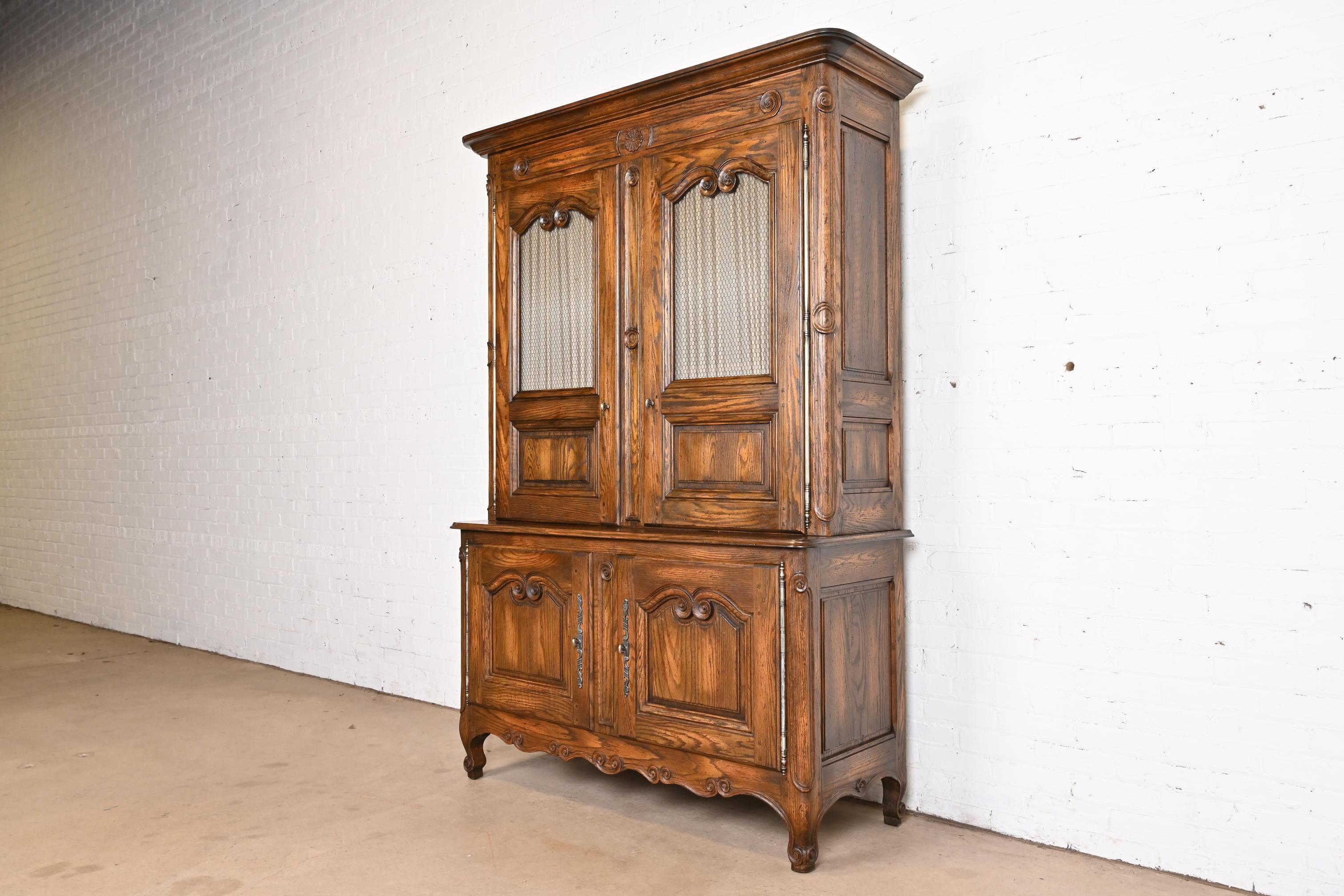 A gorgeous French Provincial Louis XV style bar cabinet

By Baker Furniture

USA, Circa 1960s

Carved oak, with original hardware. Interior is lighted.

Measures: 53.5