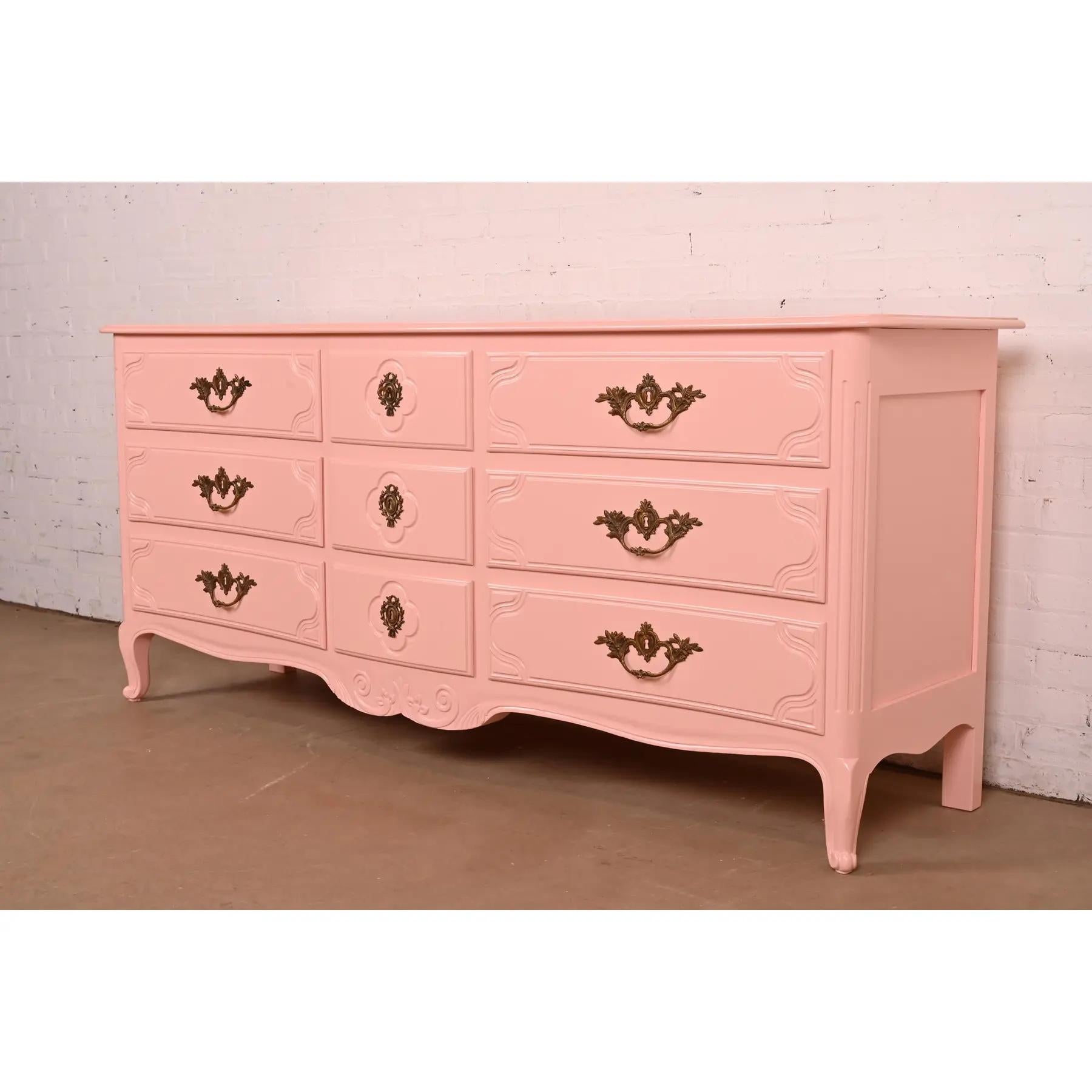 An exceptional French Provincial Louis XV style nine-drawer dresser or credenza

By Baker Furniture

USA, Circa 1960s

Pink lacquered carved solid walnut, with original brass hardware.

Measures: 76