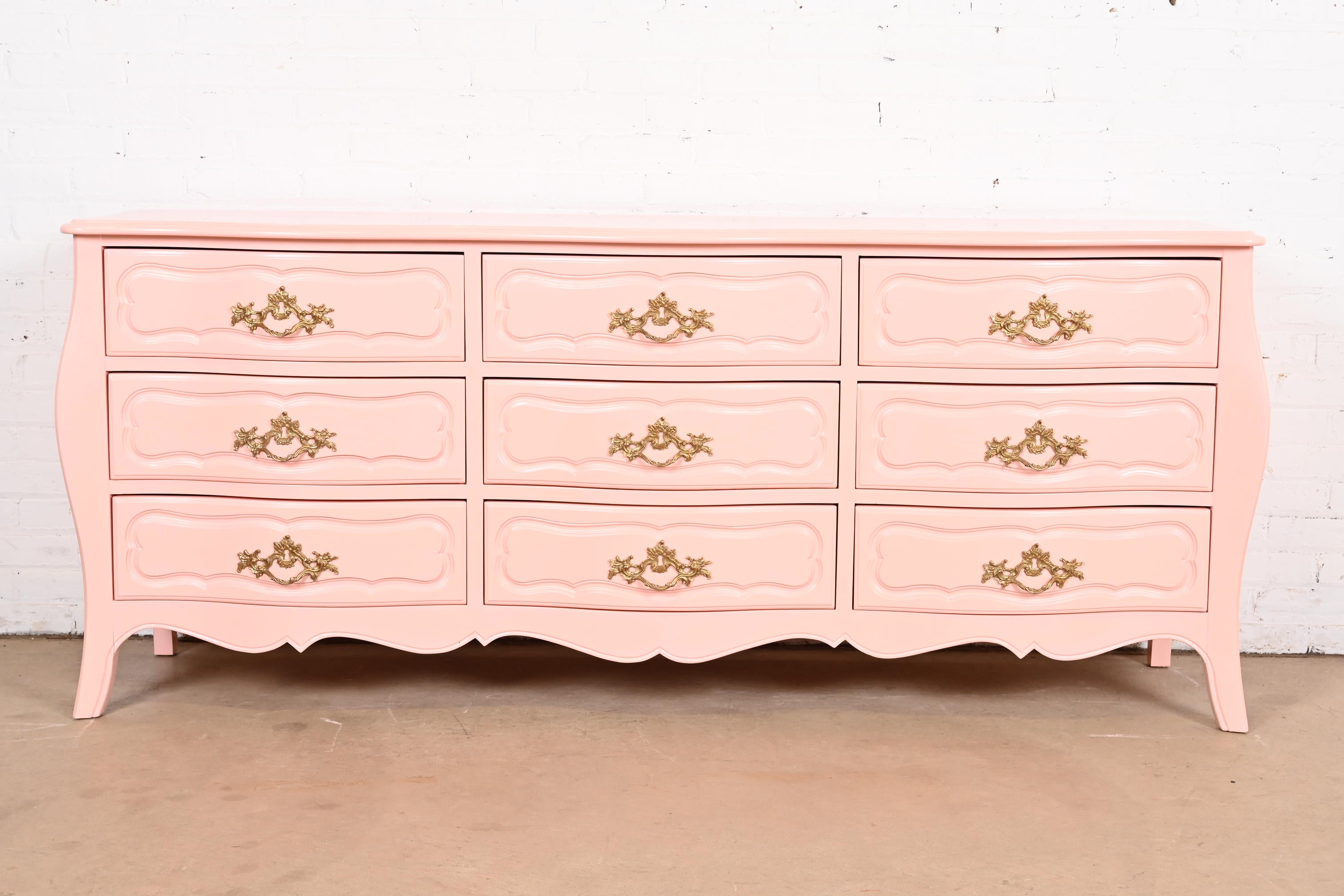A gorgeous French Provincial Louis XV style nine-drawer triple dresser or credenza

By Baker Furniture 

USA, Circa 1960s

Pink lacquered solid walnut, with original brass hardware.

Measures: 76