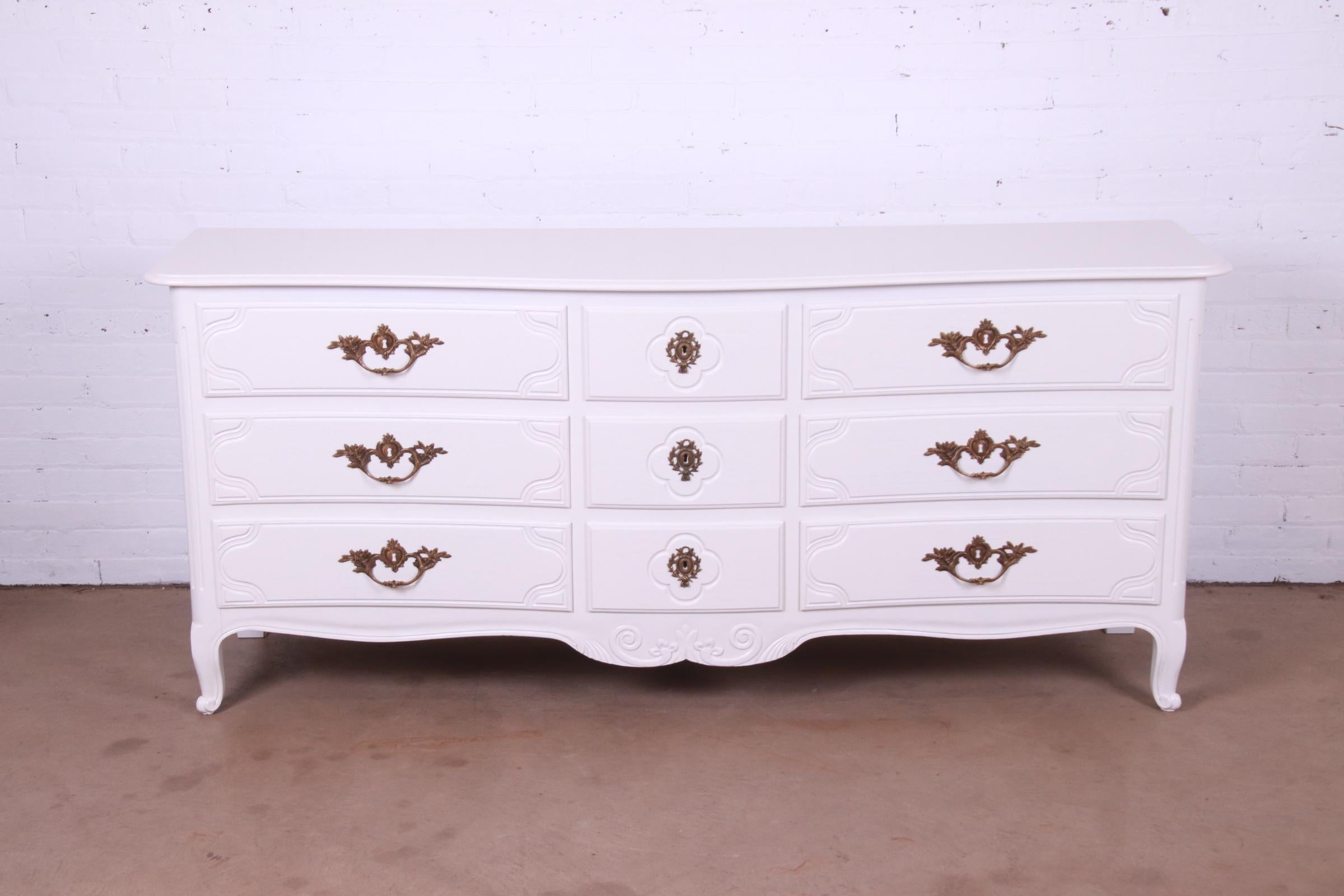 An exceptional French Provincial Louis XV style nine-drawer dresser or credenza

By Baker Furniture

USA, Circa 1960s

White lacquered carved solid walnut, with original brass hardware.

Measures: 76