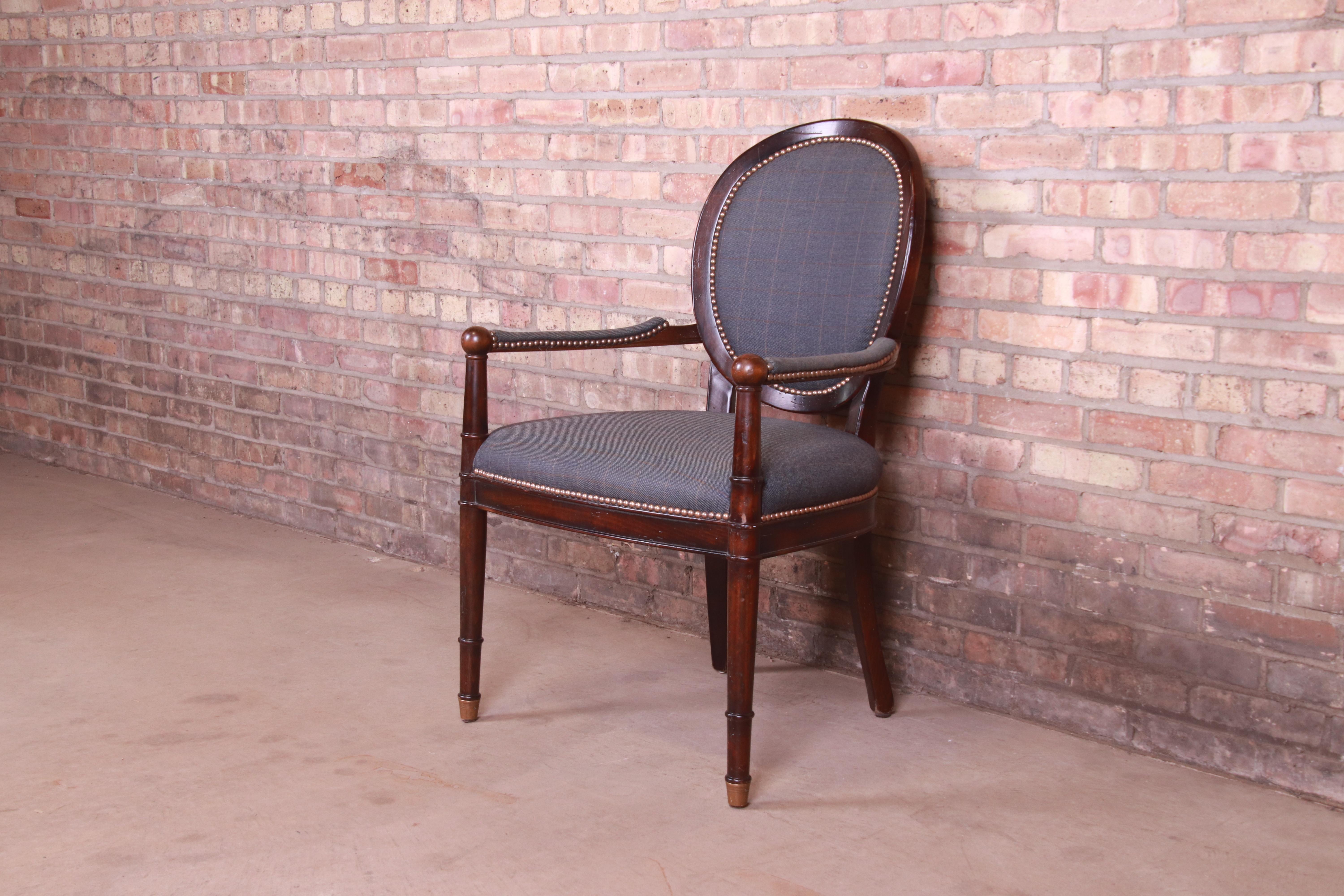 A beautiful French Provincial Louis XVI style arm chair or club chair

By Baker Furniture

USA, Late 20th Century

Carved walnut frame, with studded blue upholstery and brass-capped feet.

Measures: 25