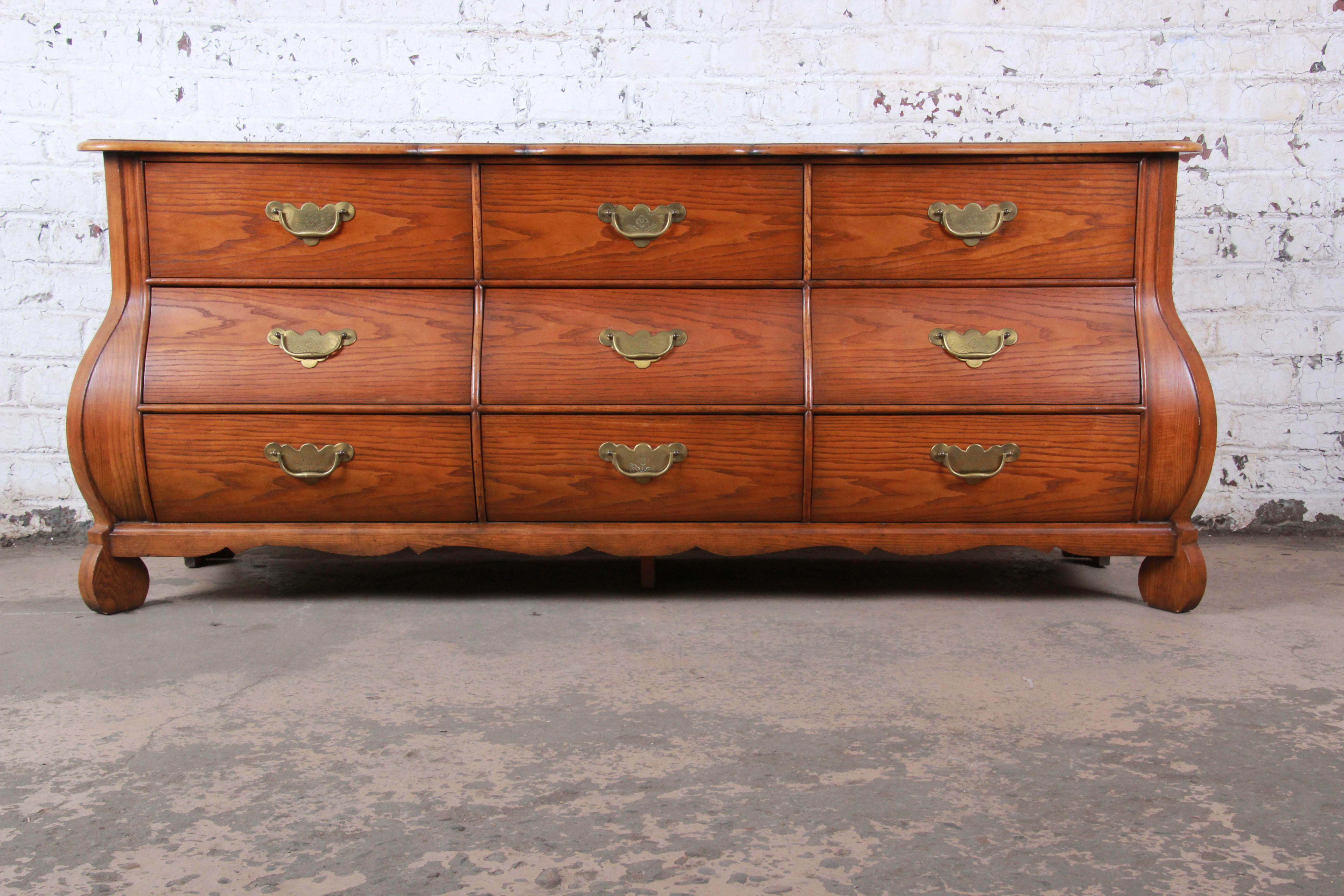 A gorgeous oak and burl wood French Provincial style Bombay long dresser or credenza

By Baker Furniture

USA, circa 1960s

Solid oak, with a burl wood top and original brass hardware.

Measures: 76.25