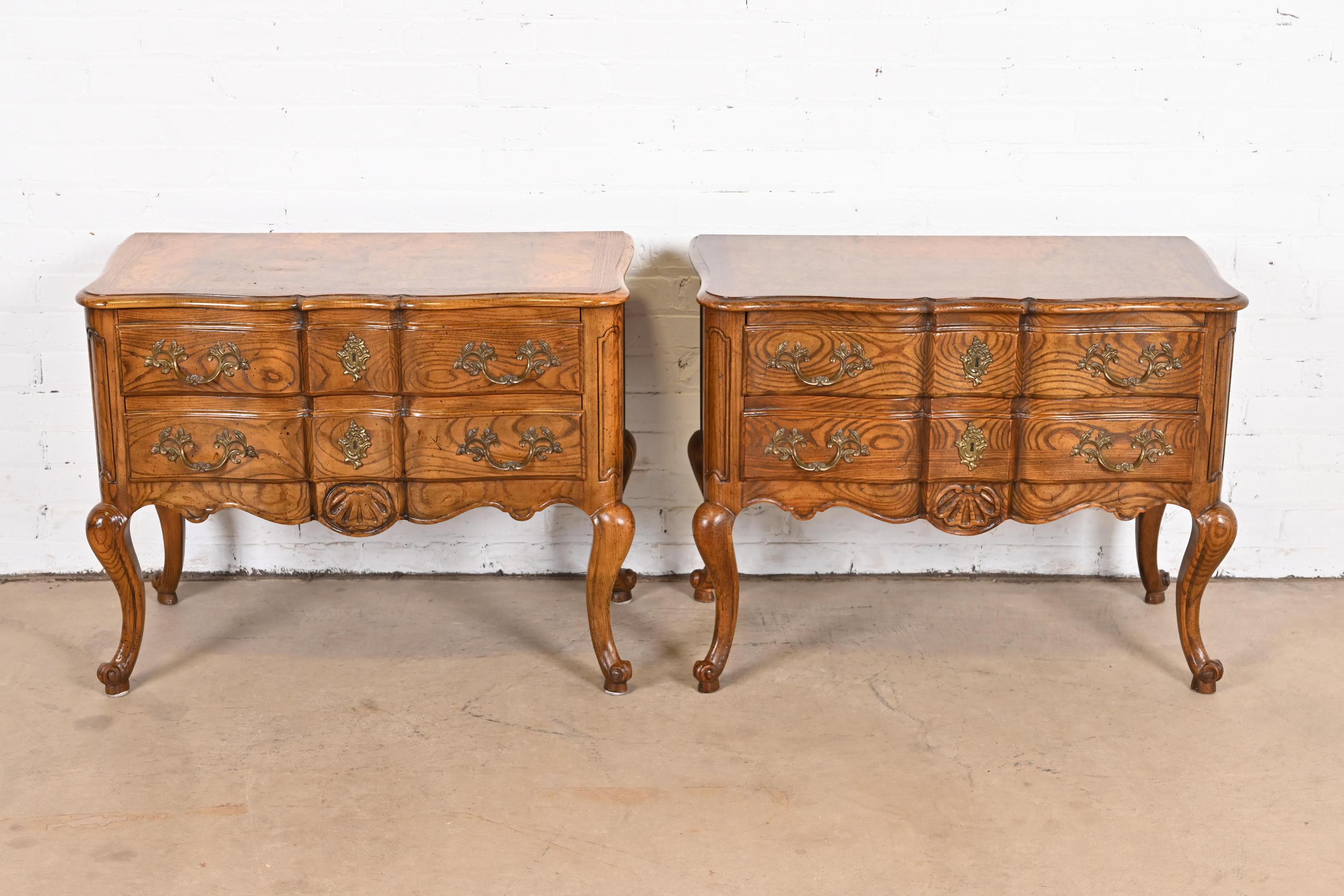 A gorgeous pair of French Provincial Louis XV style commodes, nightstands, or chests of drawers

By Baker Furniture

USA, circa 1960s

Carved oak, with gorgeous burl wood tops, and original brass hardware.

Measures: 32.25