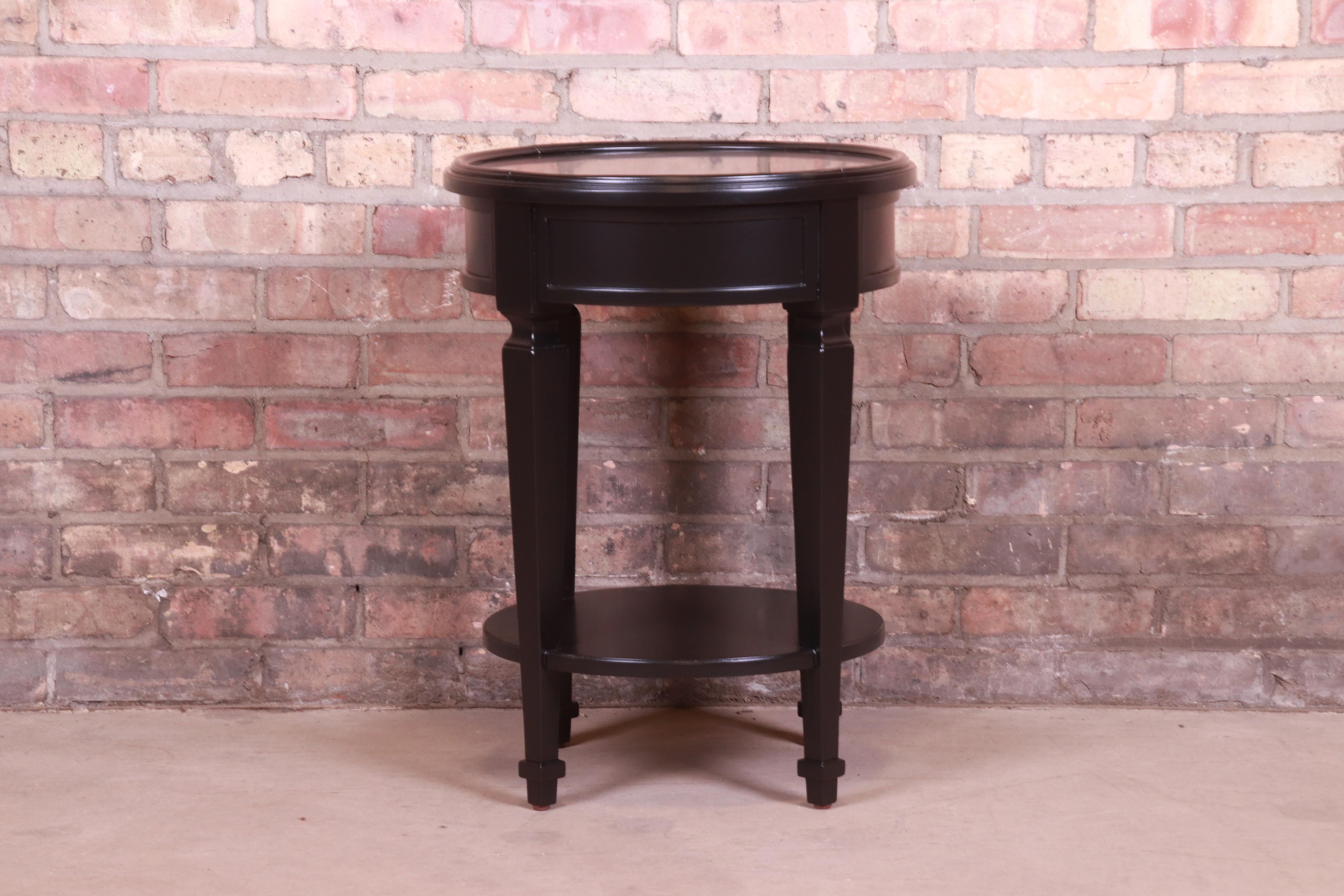A gorgeous French Regency style black lacquered mahogany two-tier occasional side table or tea table

By Baker Furniture

USA, Circa 1990s

Measures: 18