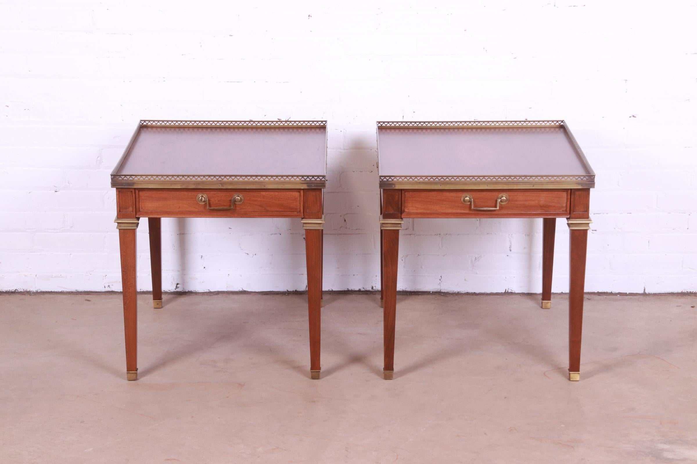 A gorgeous pair of French Regency Louis XVI style nightstands or tea tables

By Baker Furniture

USA, Circa 1960s

Walnut, with stunning burled walnut tops, pierced brass gallery, and brass hardware and accents.

Measures: 22