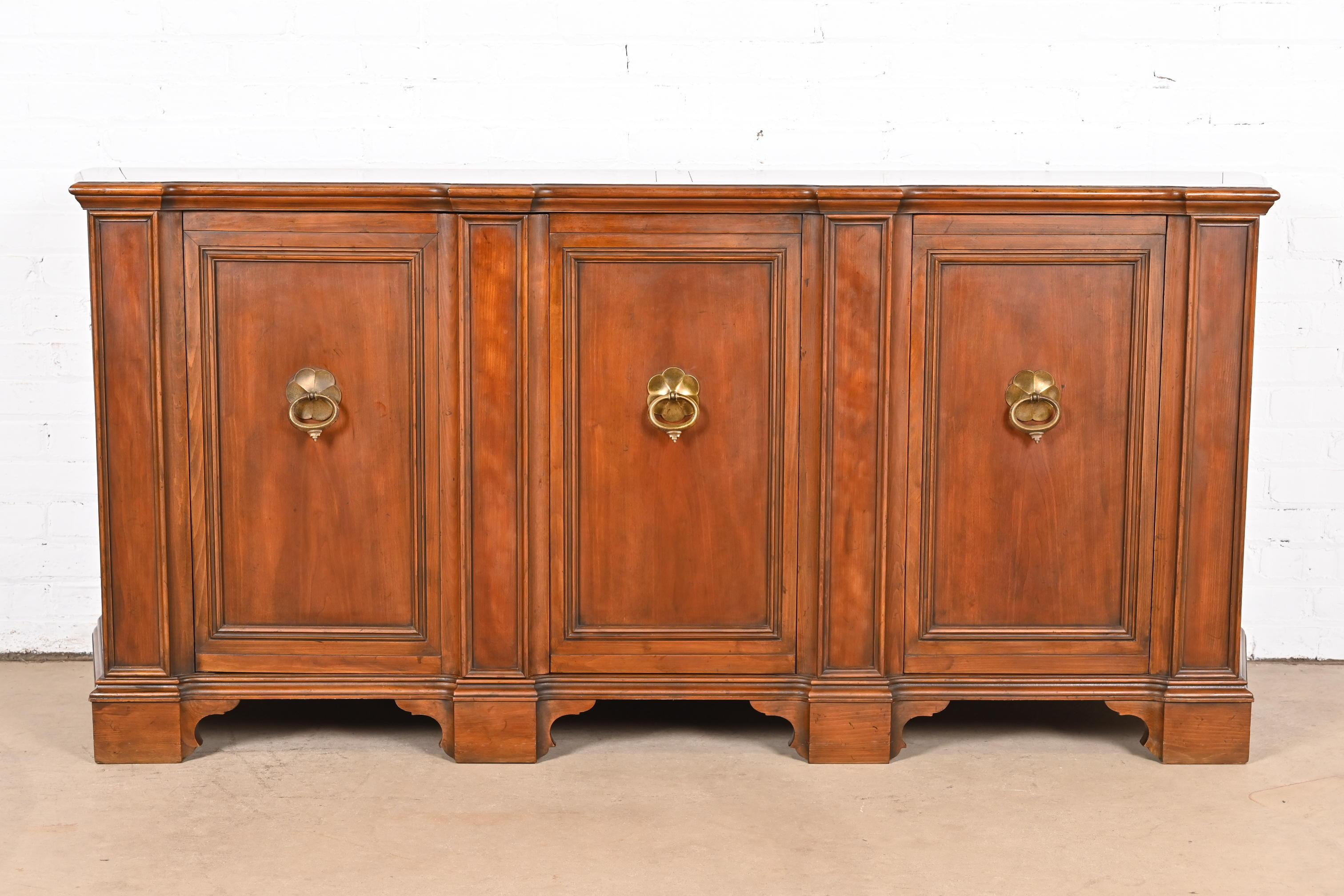 An exceptional French Regency Louis XVI style sideboard, credenza, or bar cabinet

By Baker Furniture

USA, Circa 1960s

Gorgeous carved solid cherry wood, with original brass hardware. Shelves are adjustable

Measures: 72.38
