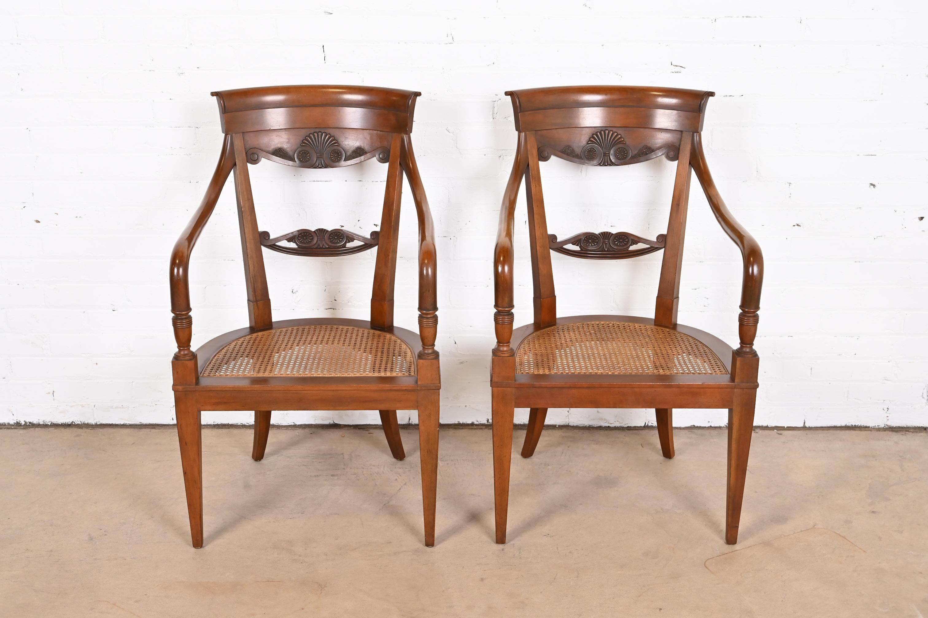 A gorgeous pair of French Regency Louis XVI style armchairs or club chairs

By Baker Furniture

USA, Circa 1980s

Carved walnut, with cane seats, and pink upholstered removable seat cushions.

Measures: 22.5